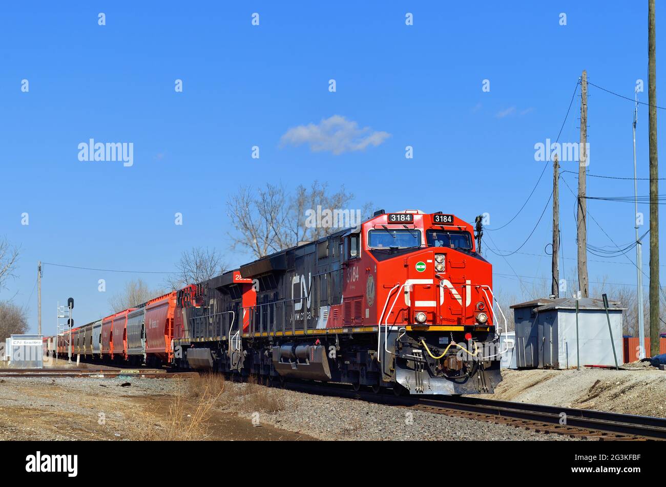 Bartlett, Illinois, USA. Ein Paar Canadian National Railway-Lokomotiven führt einen Getreidezug in südlicher Richtung durch Spaulding Junction. Stockfoto