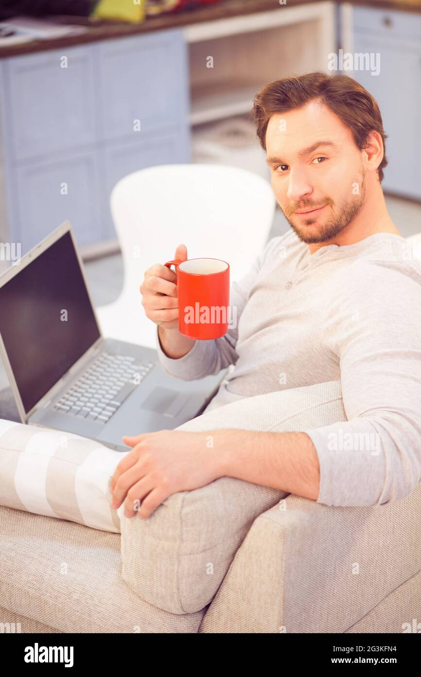 Mann trinkt Kaffee vor dem Laptop Stockfoto