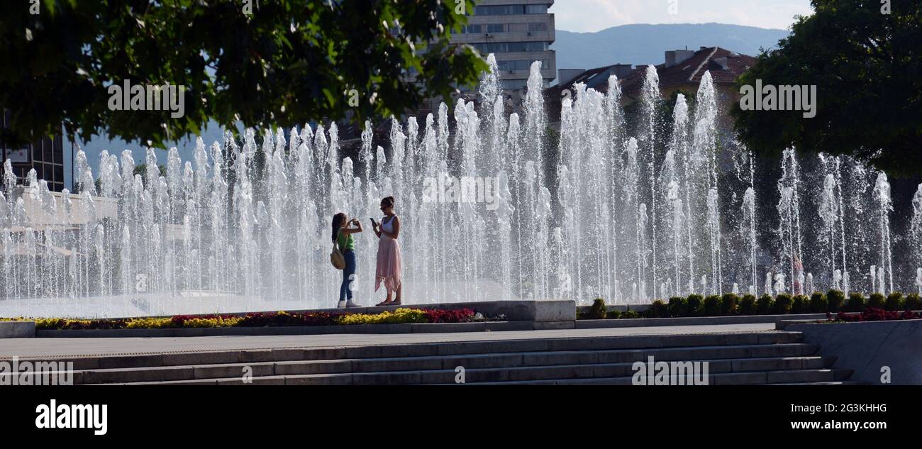 Tourist steht an den NDK Wasserfontänen in der Nähe des Nationalen Kulturpalastes in Sofia, Bulgarien. Stockfoto