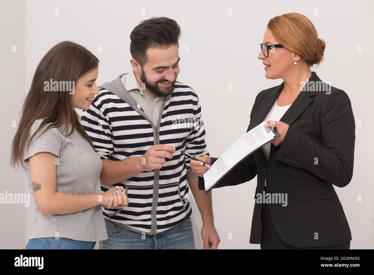 Immobilienmakler auf einen Platz im Kaufvertrag, wo die neuen Besitzer haben eine Unterschrift setzen. Stockfoto