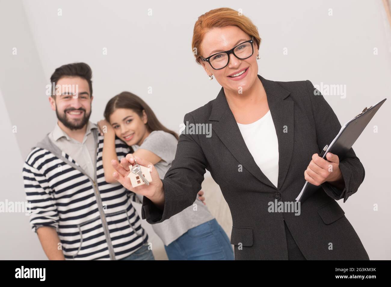 Makler ist bereit, die Schlüssel einer Wohnung an die neuen Eigentümer übergeben, nach der Unterzeichnung der Vereinbarung. Stockfoto