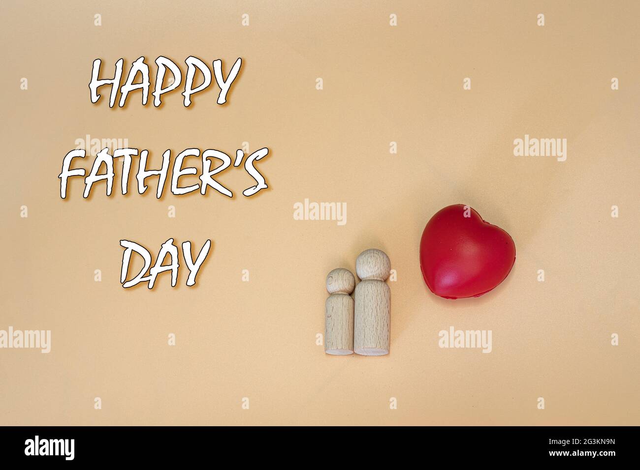 Happy Father's Day Konzept mit zwei Holzfiguren, einem roten Herzen und Text. Stockfoto