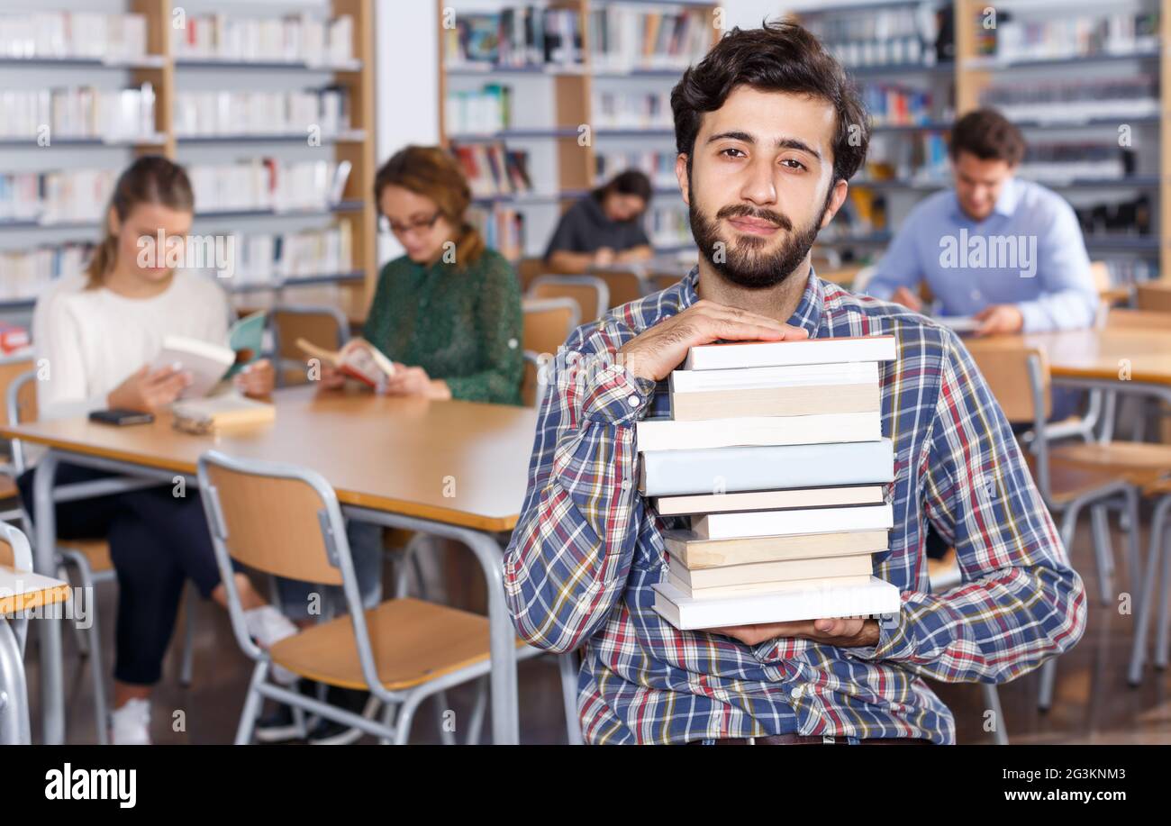 Porträt eines bärtigen Mannes mit Bücherstapel Stockfoto