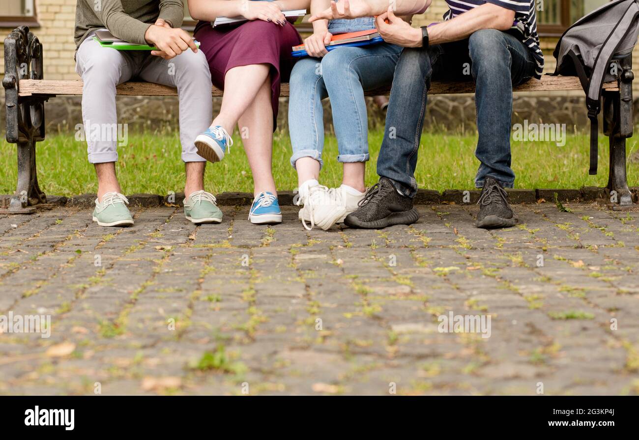 Nahaufnahme auf Beinen junge Leute sitzen auf Bank. Stockfoto