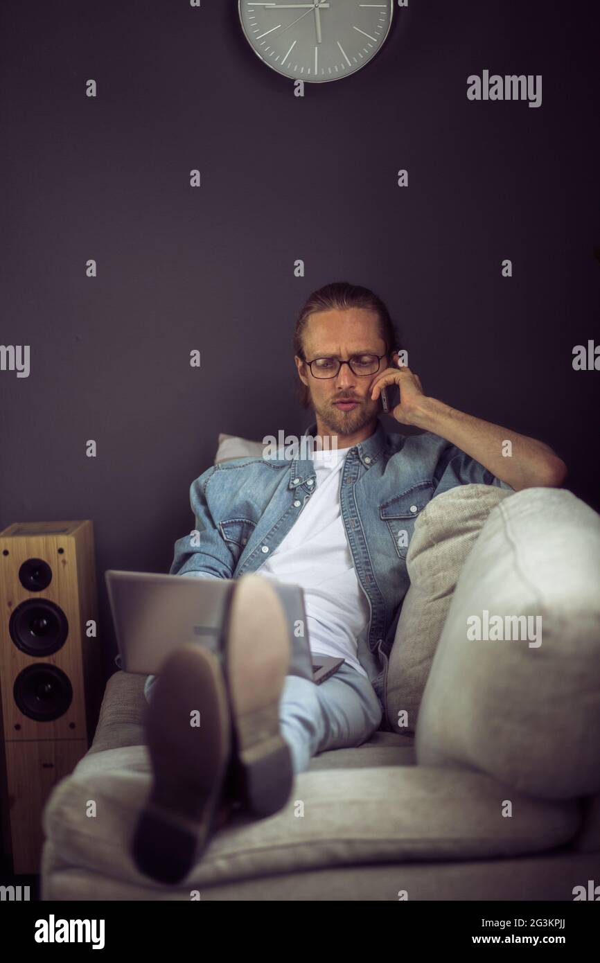 Telefongespräch von Freiberufler liegen zu Hause Büro. Stockfoto