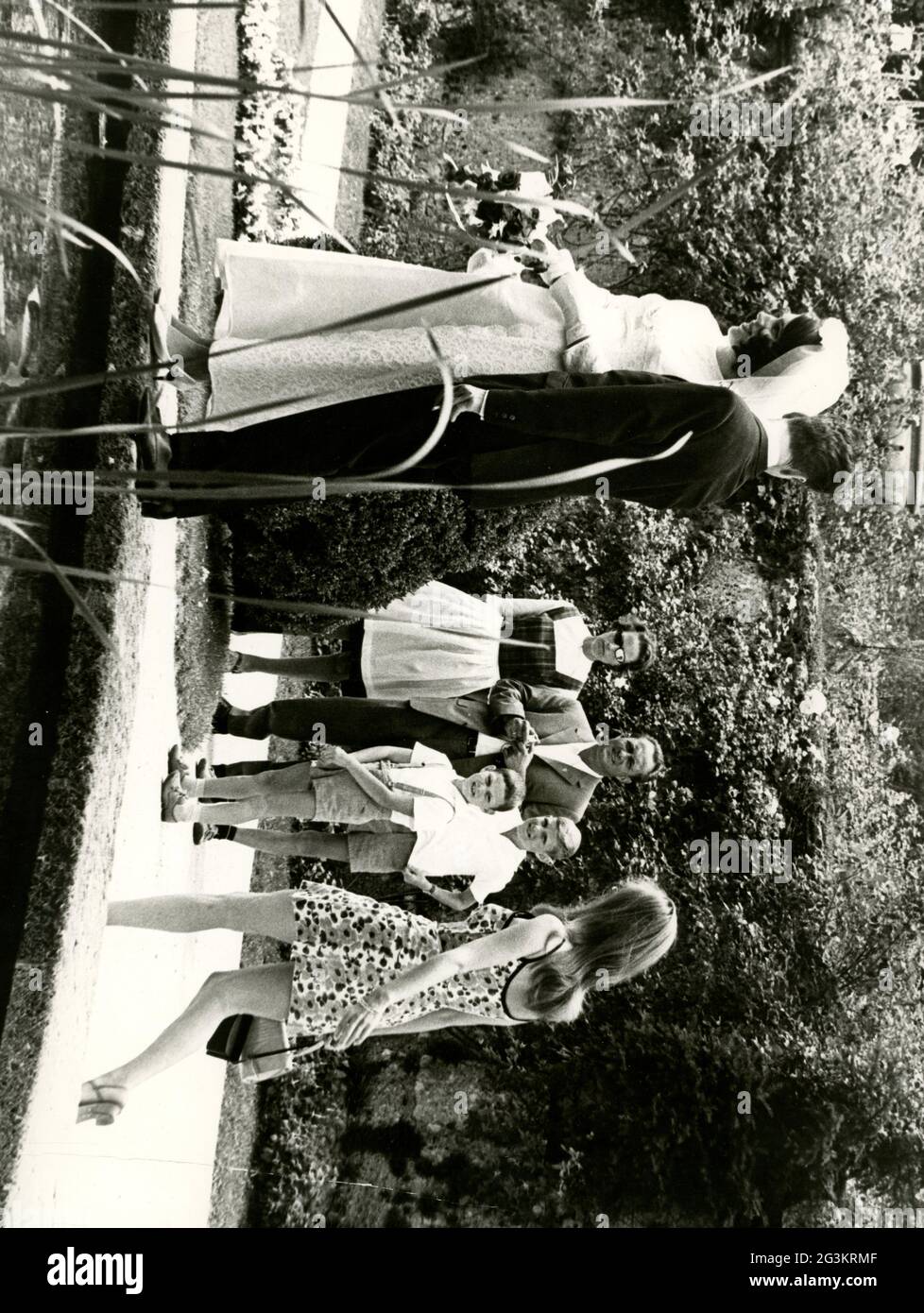 Menschen, Hochzeit, Brautpaar posiert in einem Park, Brautpaar schaut auf eine andere Frau, um 1970, ZUSÄTZLICHE-RIGHTS-CLEARANCE-INFO-NOT-AVAILABLE Stockfoto