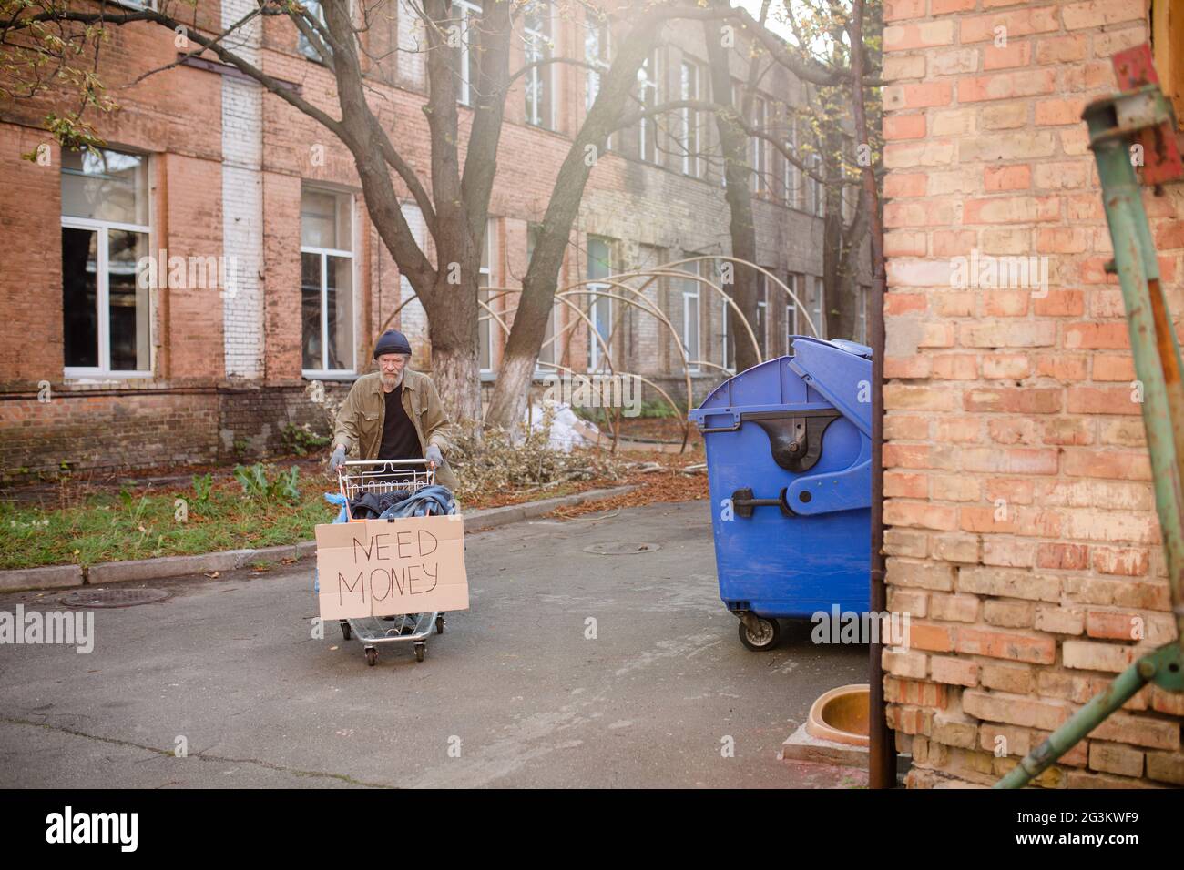 Obdachlose Bettler mit gestohlenen Warenkorb mit Platine brauchen Geld. Stockfoto