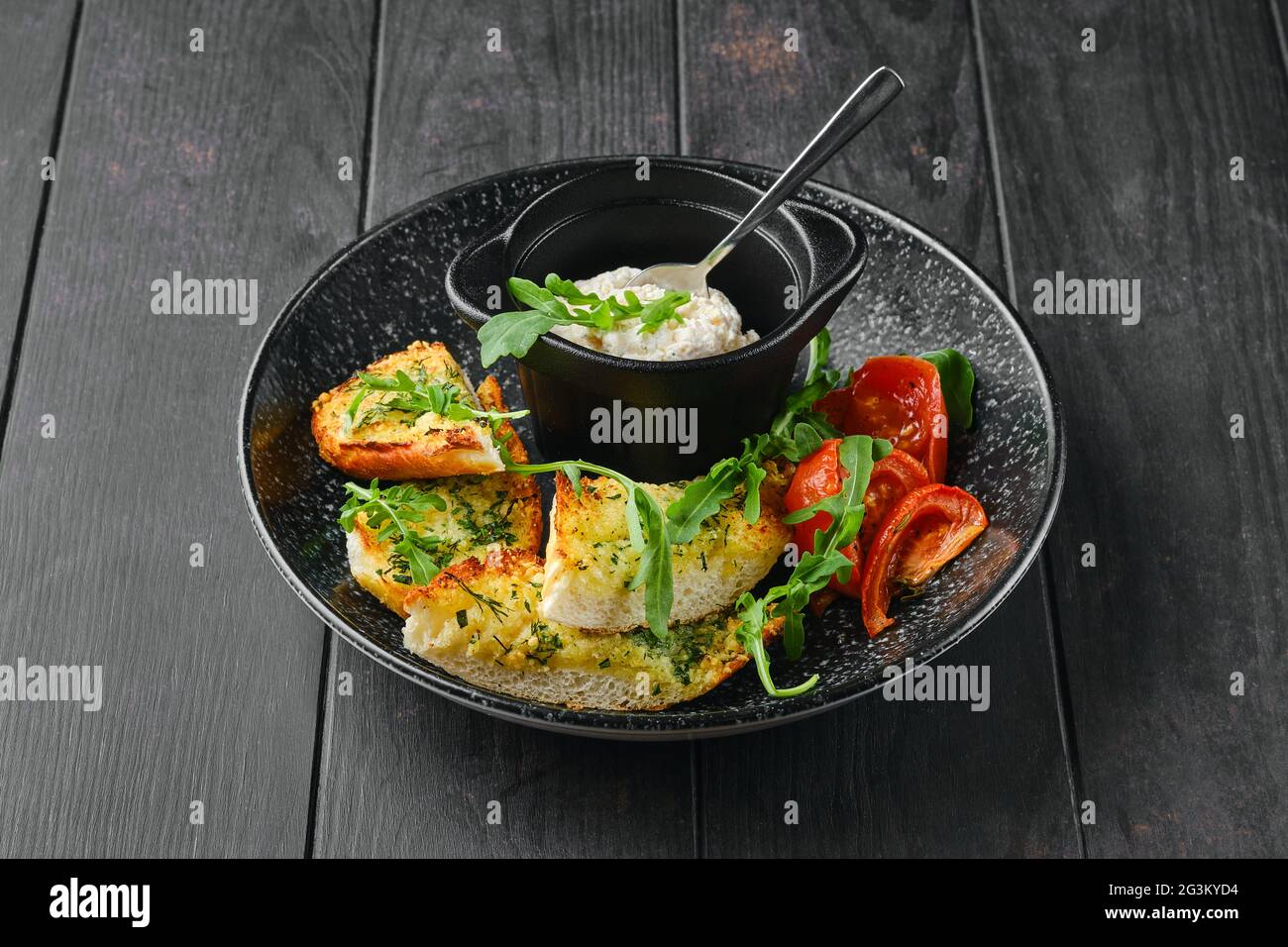 Geröstetes Knoblauchbrot, Tomate und Hühnerpastete auf einem Teller Stockfoto