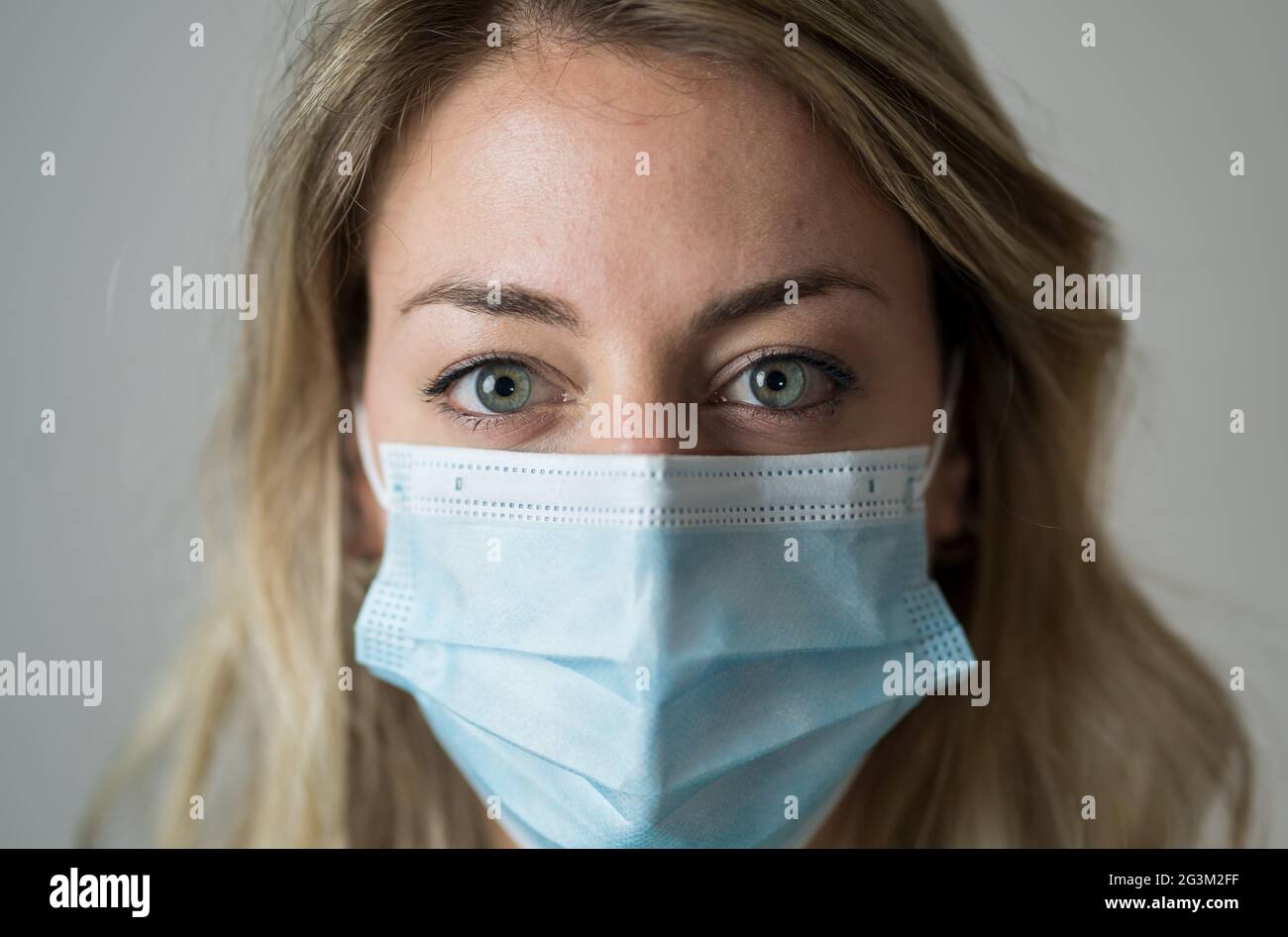 Porträt einer Ärztin oder Krankenschwester, die Peeling und eine medizinische Gesichtsmaske trägt. Emotionaler Stress durch überarbeiteter Gesundheitsfachkräfte und Ärzte Stockfoto