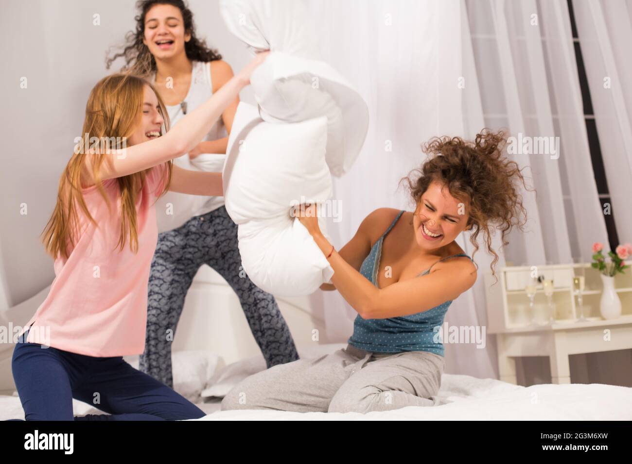 Mädchen im Bett mit Kissen kämpfen im Pyjama Stockfoto