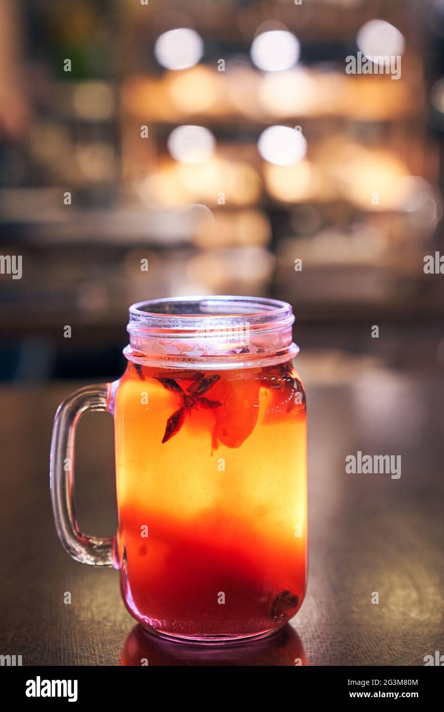 Nahaufnahme eines alkoholfreien Glühweins mit einem Strohhalm auf dem Hintergrund des Innenraums des Cafés, bestellen Sie einen Stockfoto