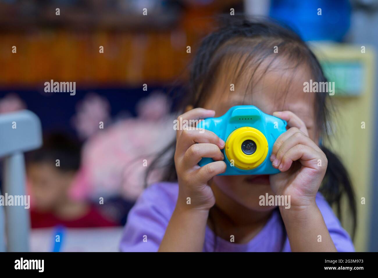 Fotografieren von anderen. Kleines Mädchen fotografieren mit Spielzeug Kamera, Fotografie Kurse. Kamera in der Hand Stockfoto