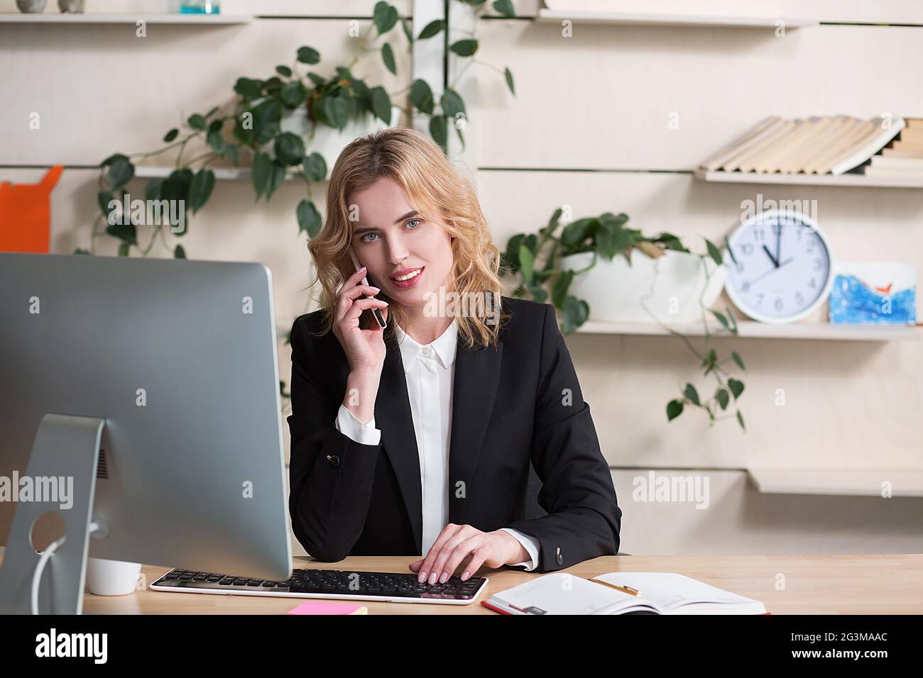 Junge Frau, die im Büro arbeitet und am Schreibtisch sitzt Stockfoto