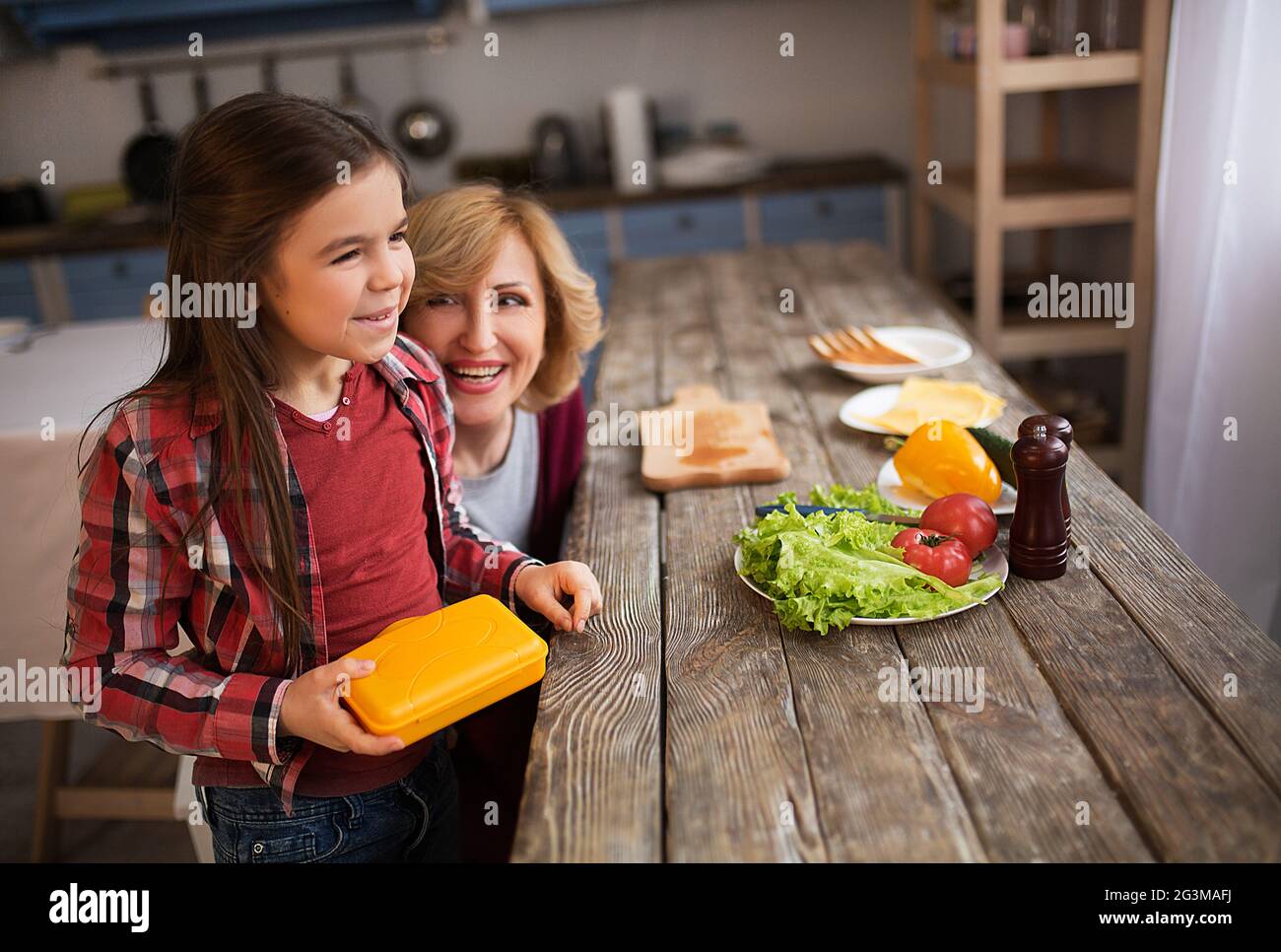 Schöne Oma und Enkelin machen Sandwiches Stockfoto