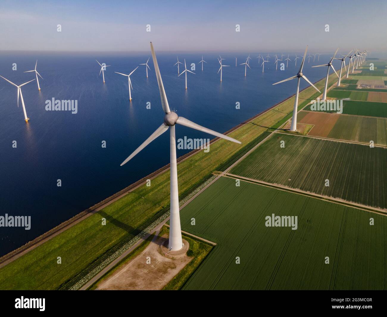 Windturbine aus der Luft, Blick auf die Drohne im Windpark ein Windmühlenpark im See IJsselmeer der größte in den Niederlanden, nachhaltige Entwicklung, erneuerbare Energien. Stockfoto