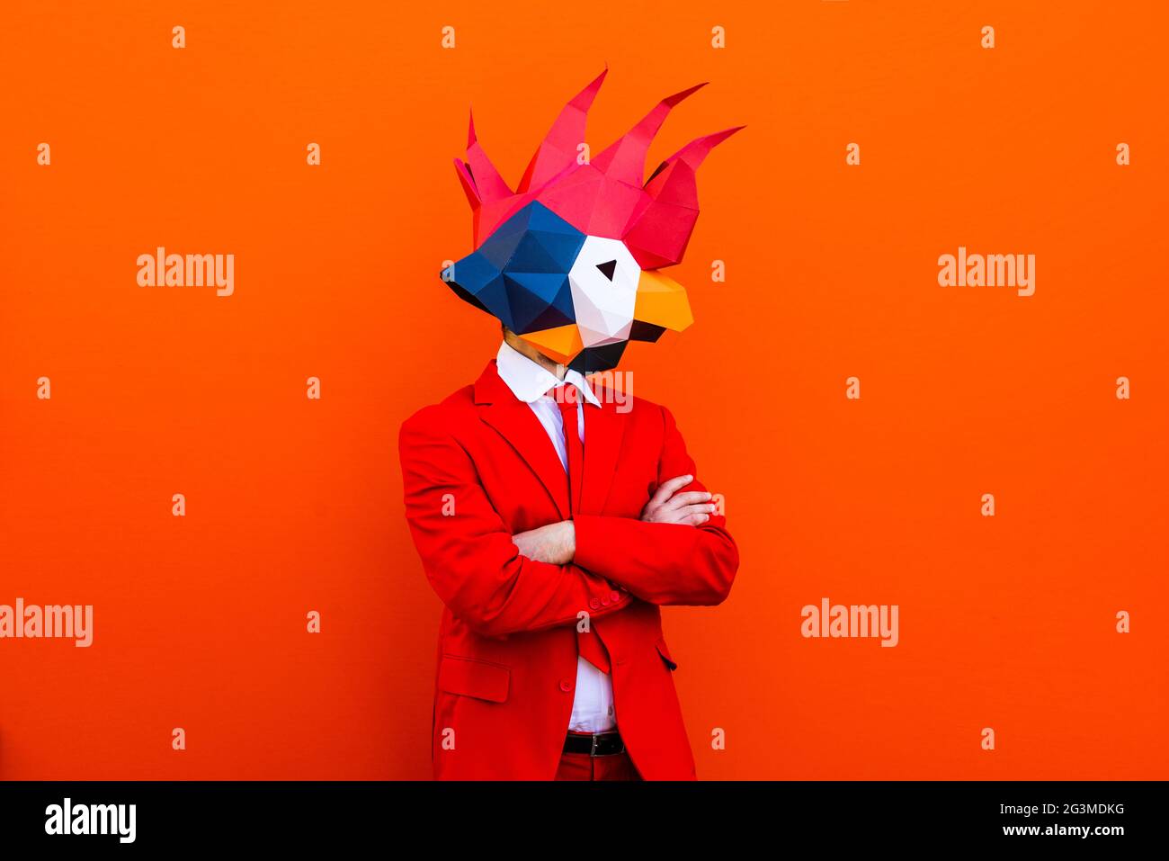 Cooler Mann trägt 3d Origami Maske mit stilvollen farbigen Kleidung - Kreatives Konzept für die Werbung, Tier Kopf Maske dabei lustige Dinge auf bunten Rücken Stockfoto