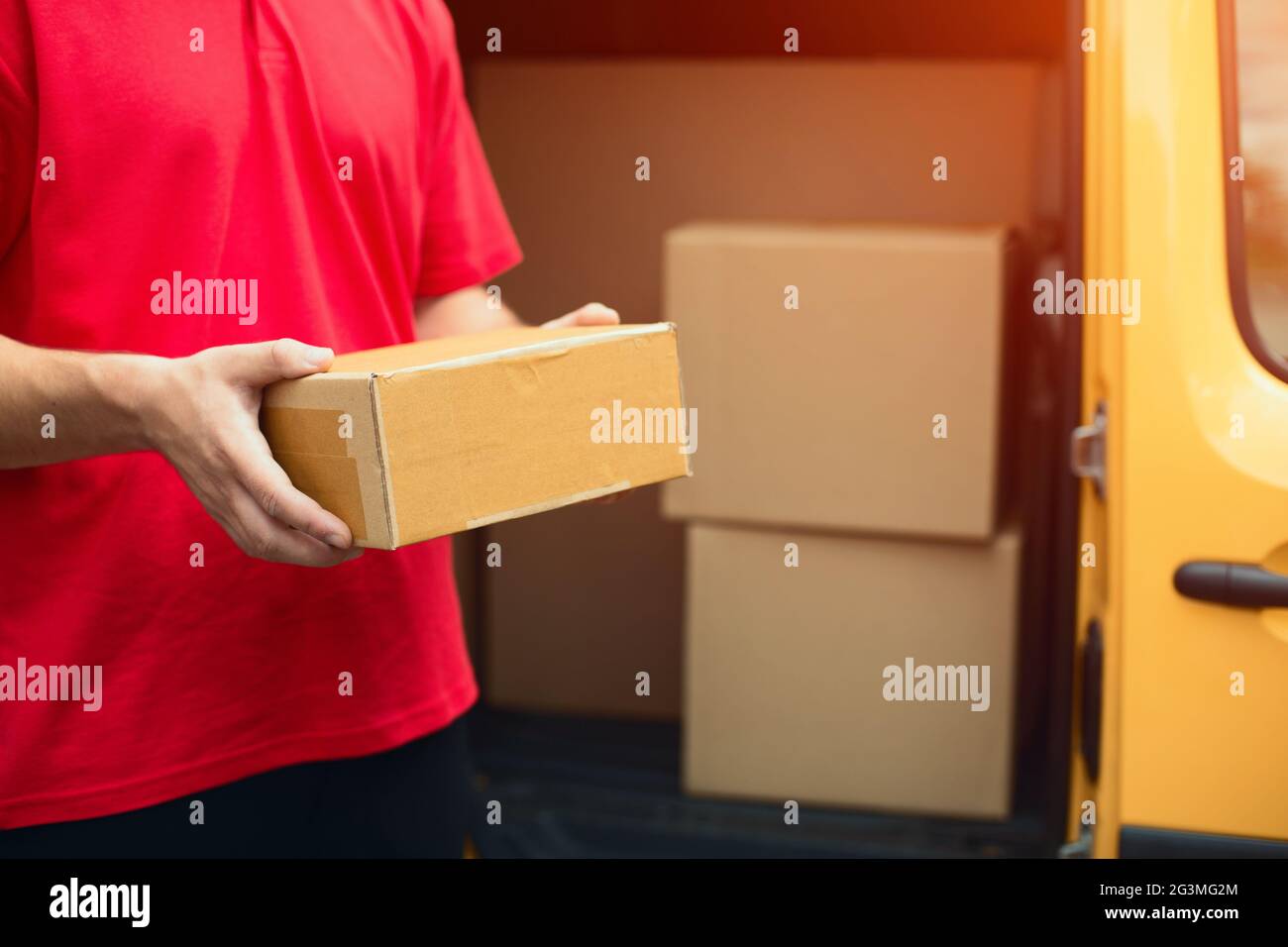 Lieferung Kerl holding Paket. Stockfoto
