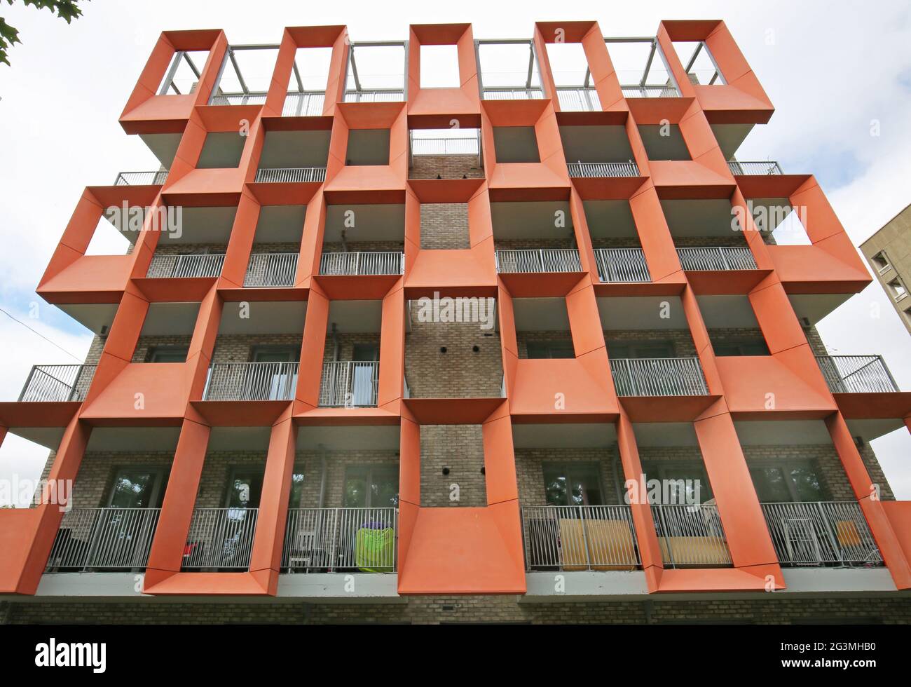 Desticative, orangefarbene, glasverstärkte Zementplatten (GRC) auf einem neu erbauten Block von Local Authority Apartments in Hackney, London, Großbritannien Stockfoto