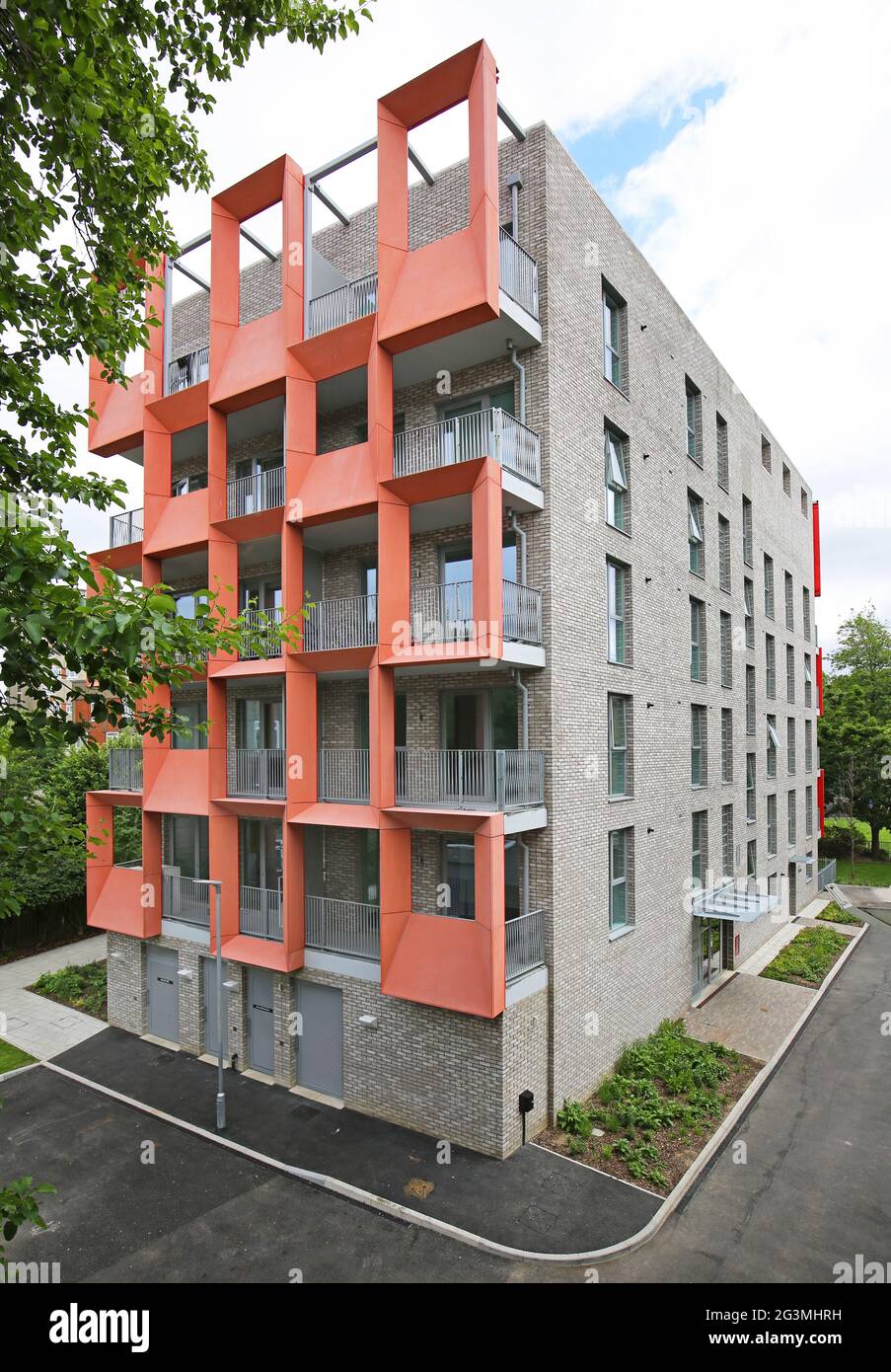 Desticative, orangefarbene, glasverstärkte Zementplatten (GRC) auf einem neu erbauten Block von Local Authority Apartments in Hackney, London, Großbritannien Stockfoto
