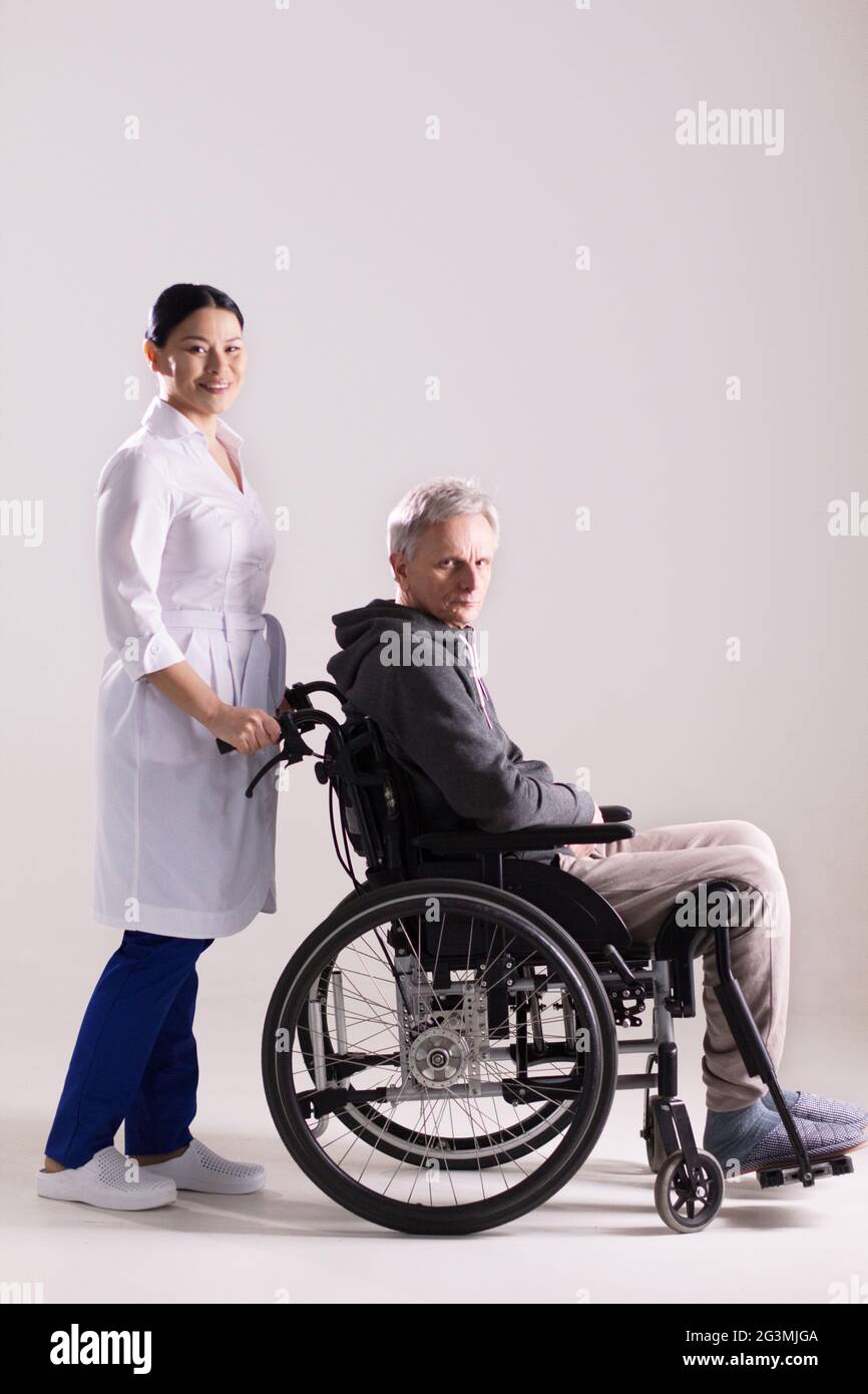 Krankenschwester Rollstuhl schieben mit dem Menschen. Stockfoto