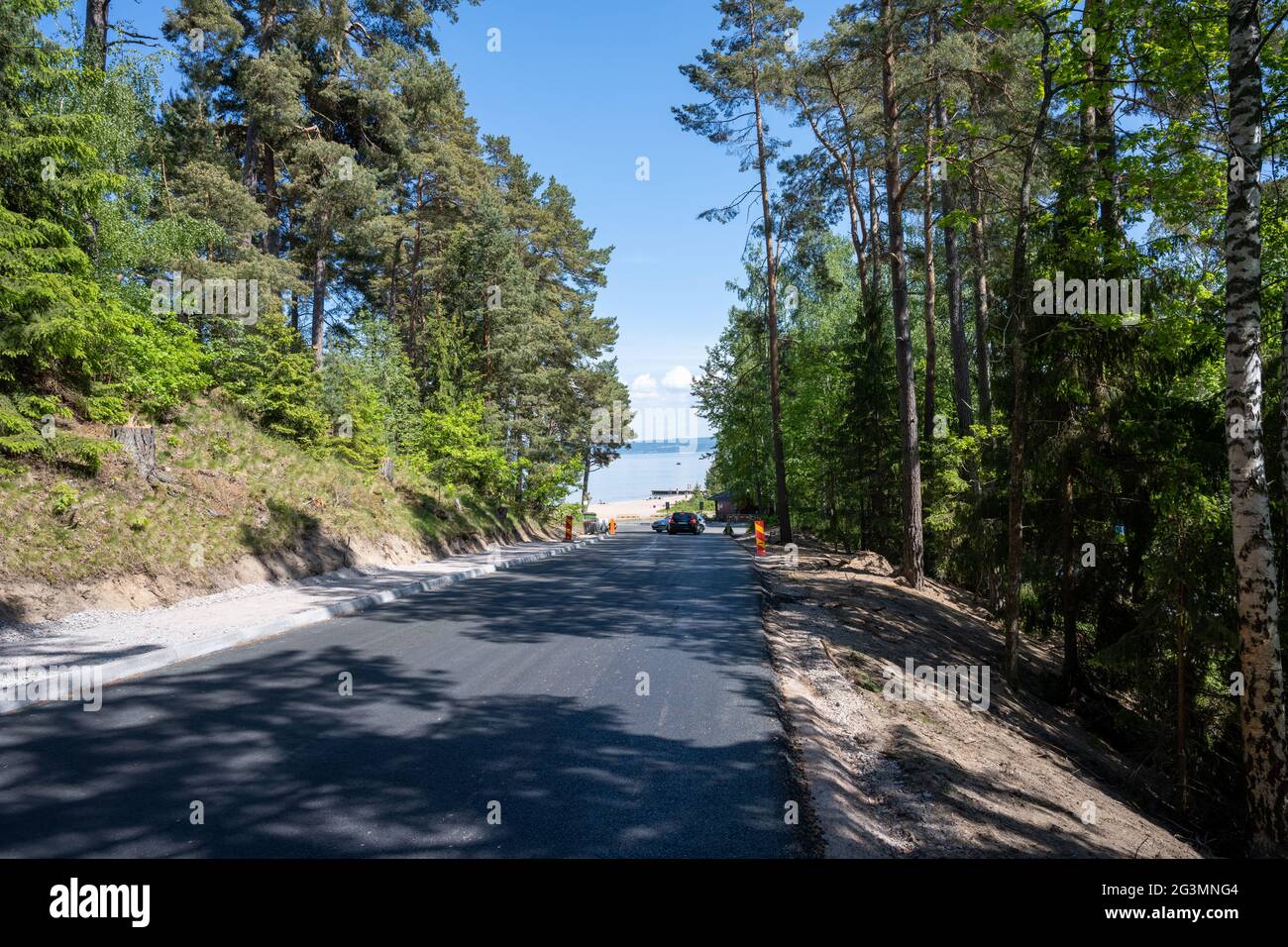 5. Juni 2021 - Habo, Schweden: Eine neu gepflasterte Straße hinunter zum Domsand-Strand, See Vattern ein heißer Sommertag. Stockfoto