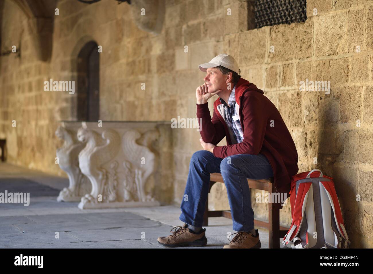 Tourist, der sich auf einer Bank ausruhen und in die Altstadt von Rhodos, Griechenland, blicken kann Stockfoto