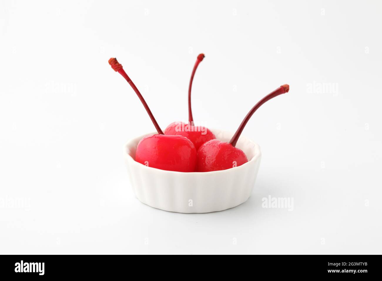 Rote Kirschen aus der Dose in Sirup auf Platte isoliert auf weißem Hintergrund Stockfoto