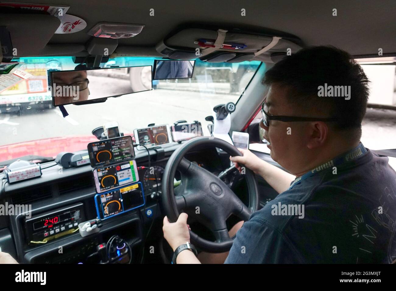 '24.03.2019, Hongkong, Hongkong, China - Taxifahrer hat zahlreiche Smartphones auf seinem Armaturenbrett. 00S190324D200CAROEX.JPG [MODELLVERSION: NEIN, EIGENTUM Stockfoto