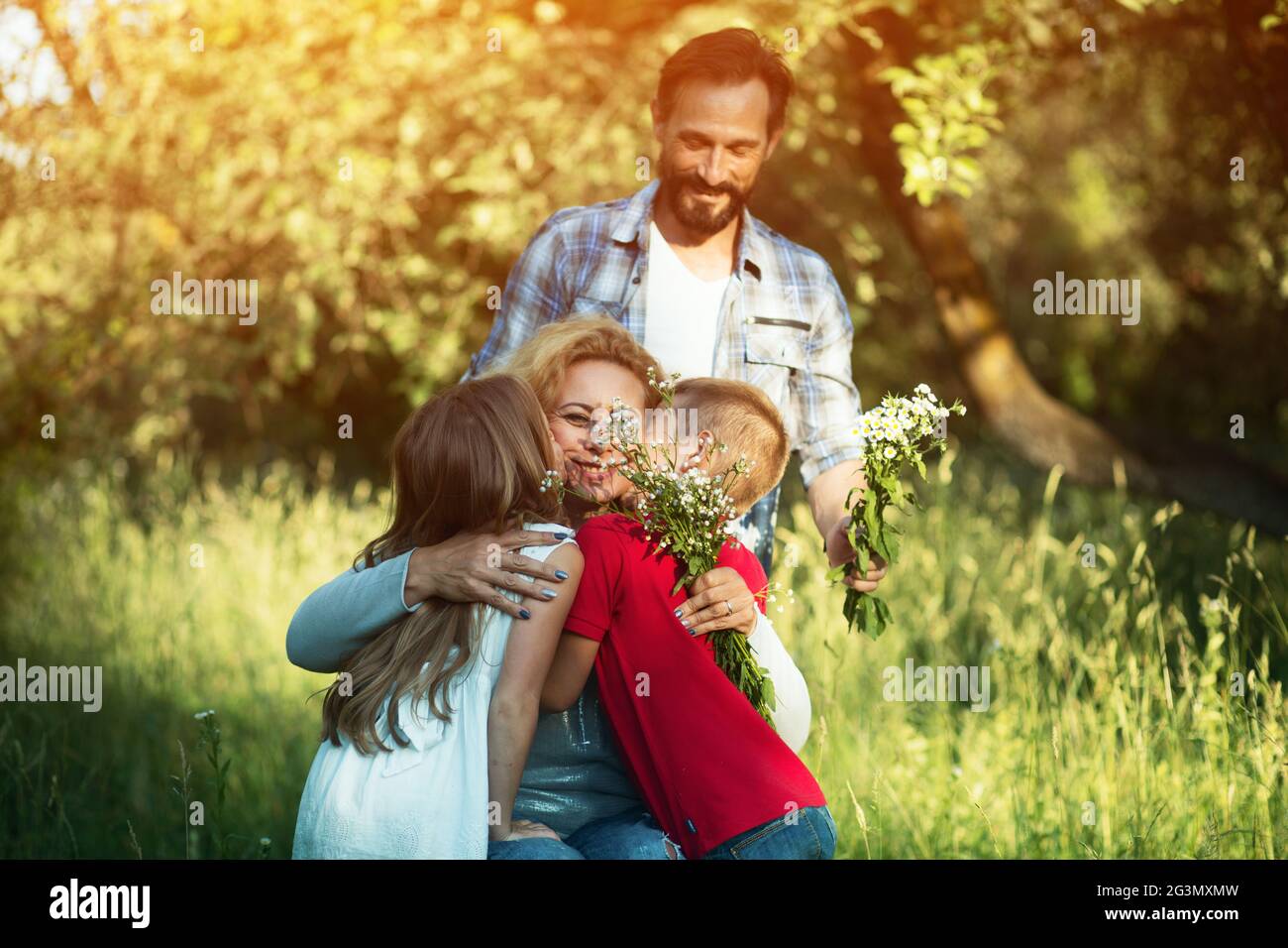 Porträt der jungen Frau im Rollstuhl ihre Familie umarmt Stockfoto