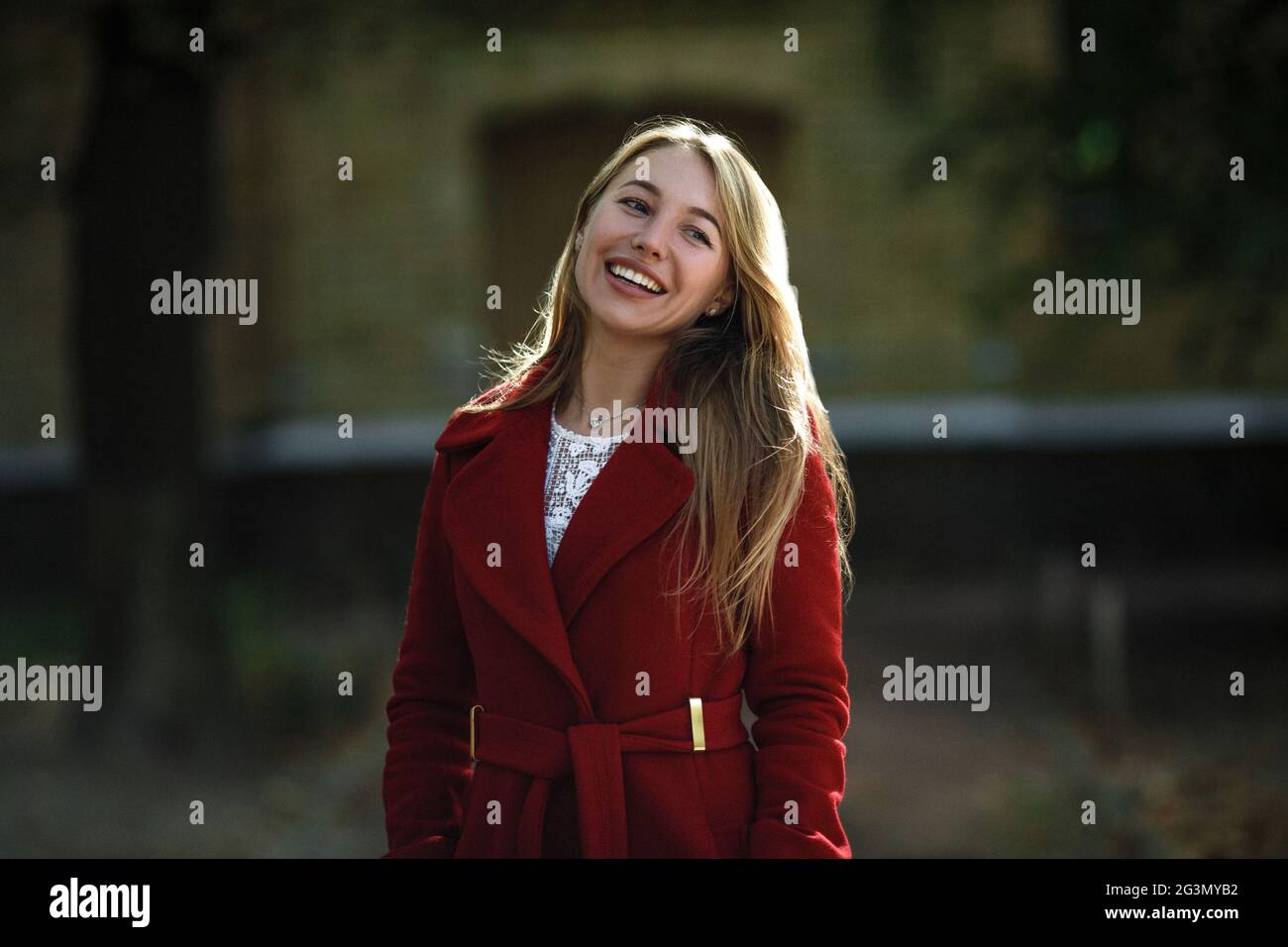 Junge Frau zu Fuß das Tragen der roten Mantel Stockfoto