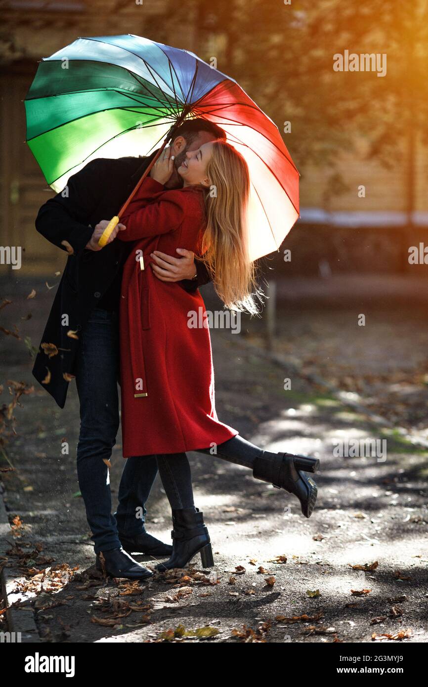 Junge Menschen wandern im Park unter bunten Regenschirm Stockfoto