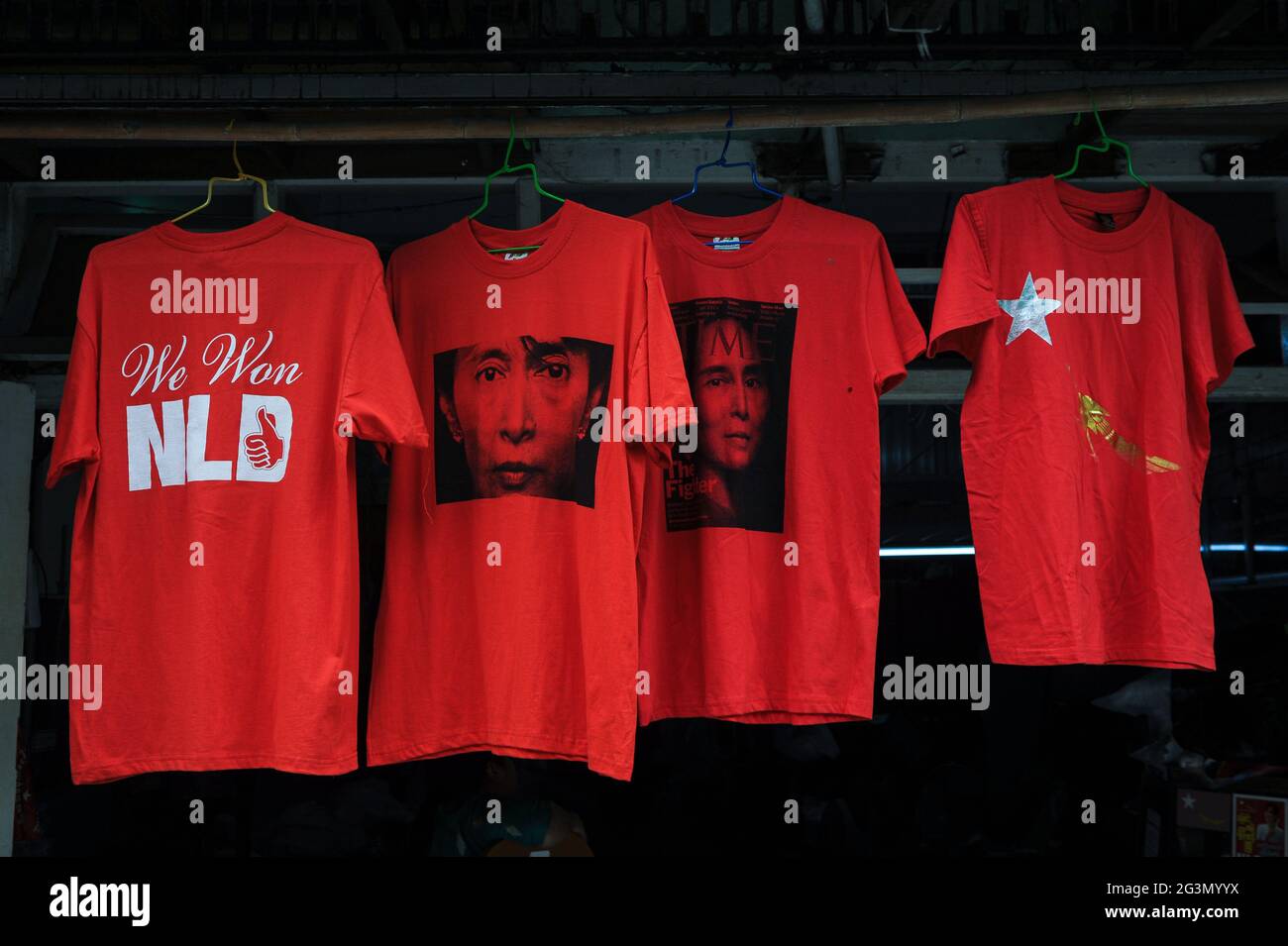 '10.11.2015, Yangon, , Myanmar - Rote T-Shirts mit dem Bild von Aung San Suu Kyi und der Aufschrift 'We won NLD' stehen in der Form an einem Straßenstand zum Verkauf Stockfoto