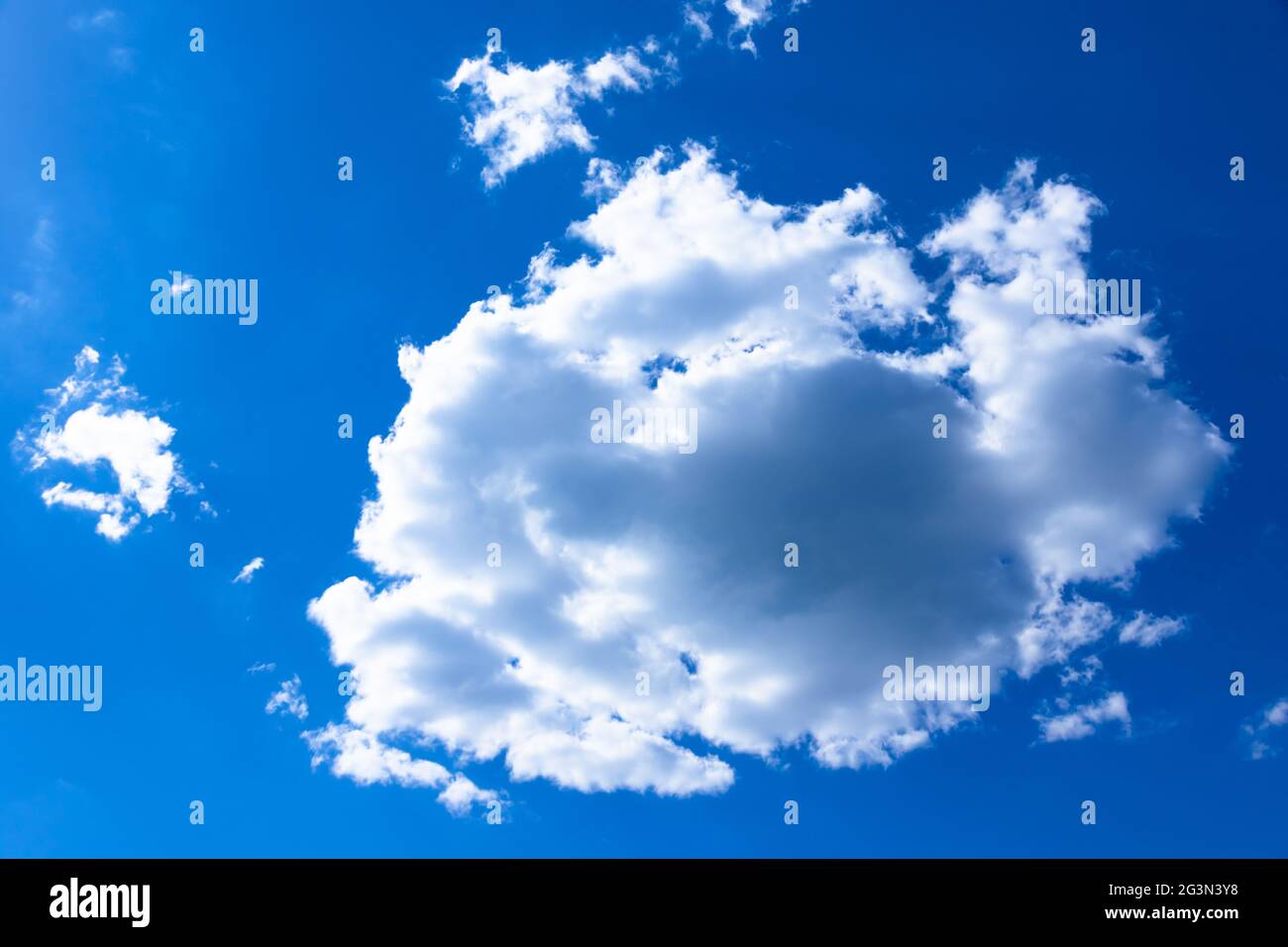 Große weiße Wolke auf einem blauen Himmel an einem hellen sonnigen Sommertag. Ländliche Landschaft. Stockfoto