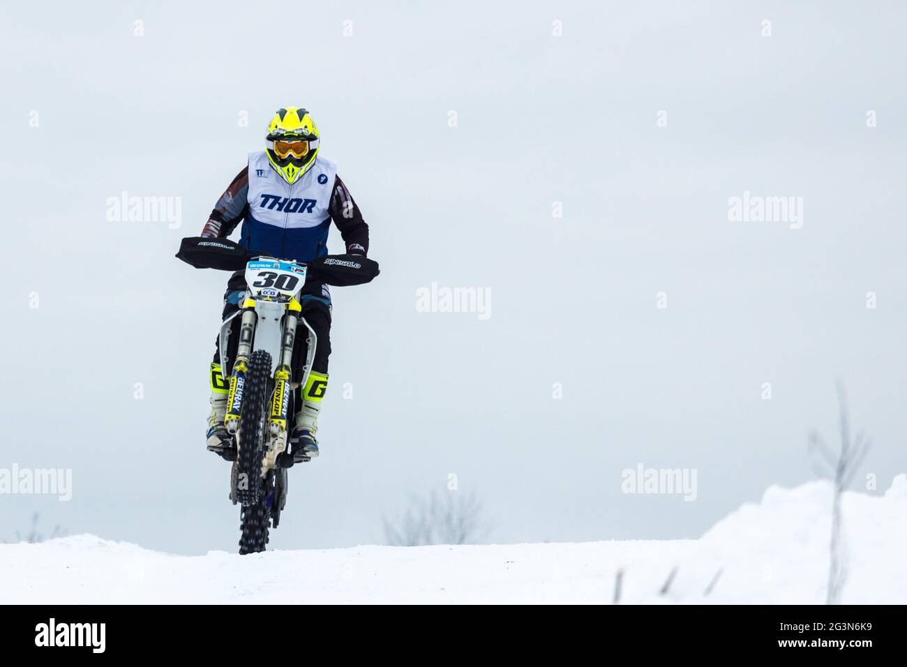 Russland Vyborg 02.23.2021 Motorradfahrer auf einem Sportmotorrad fährt an Hohe Geschwindigkeit durch den Schnee außerhalb der Stadt Stockfoto