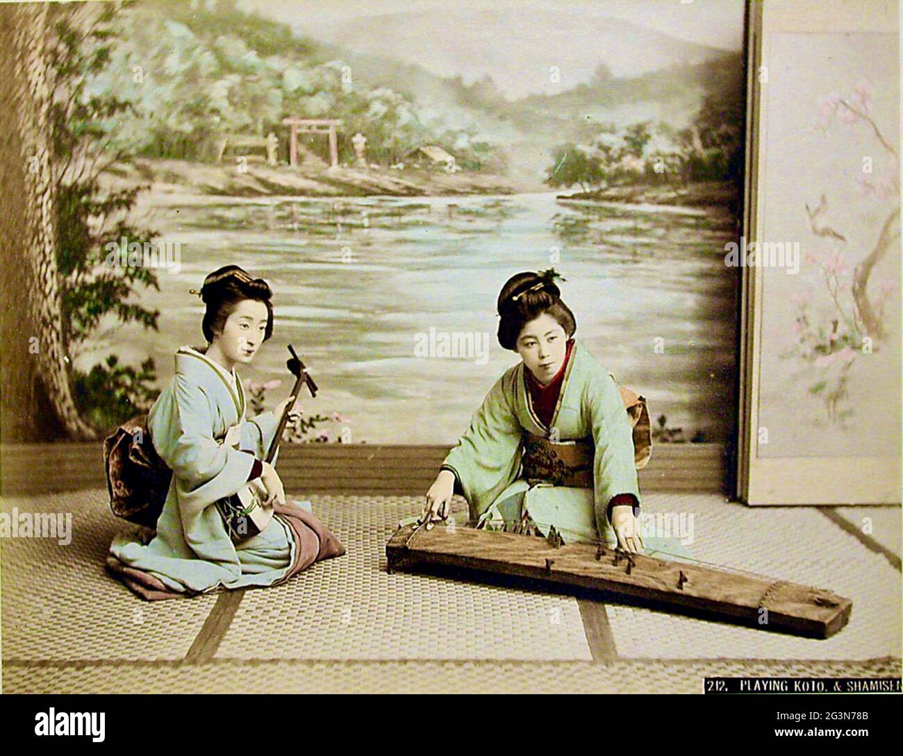 Alte Kusakabe Kimbei Fotografie aus dem alten Japan - zwei japanische Frauen spielen die traditionellen Musikinstrumente Koto und Shamisen. Stockfoto