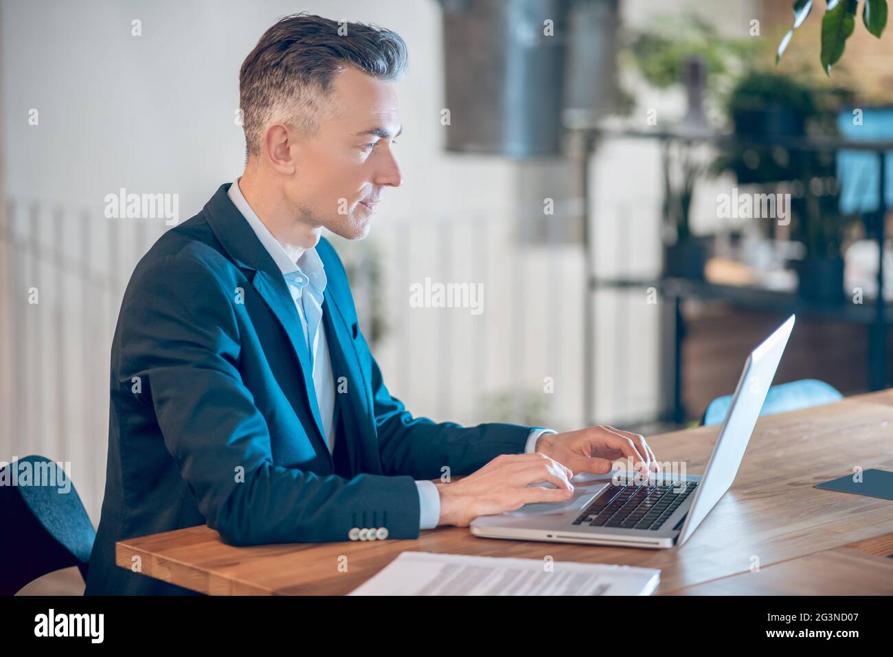 Konzentrierter Mann, der im Büro am Laptop arbeitet Stockfoto