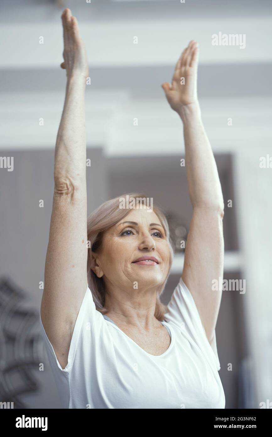 Schöne Frau über 50 Jahre alt mag Yoga zu Hause zu tun. Stockfoto