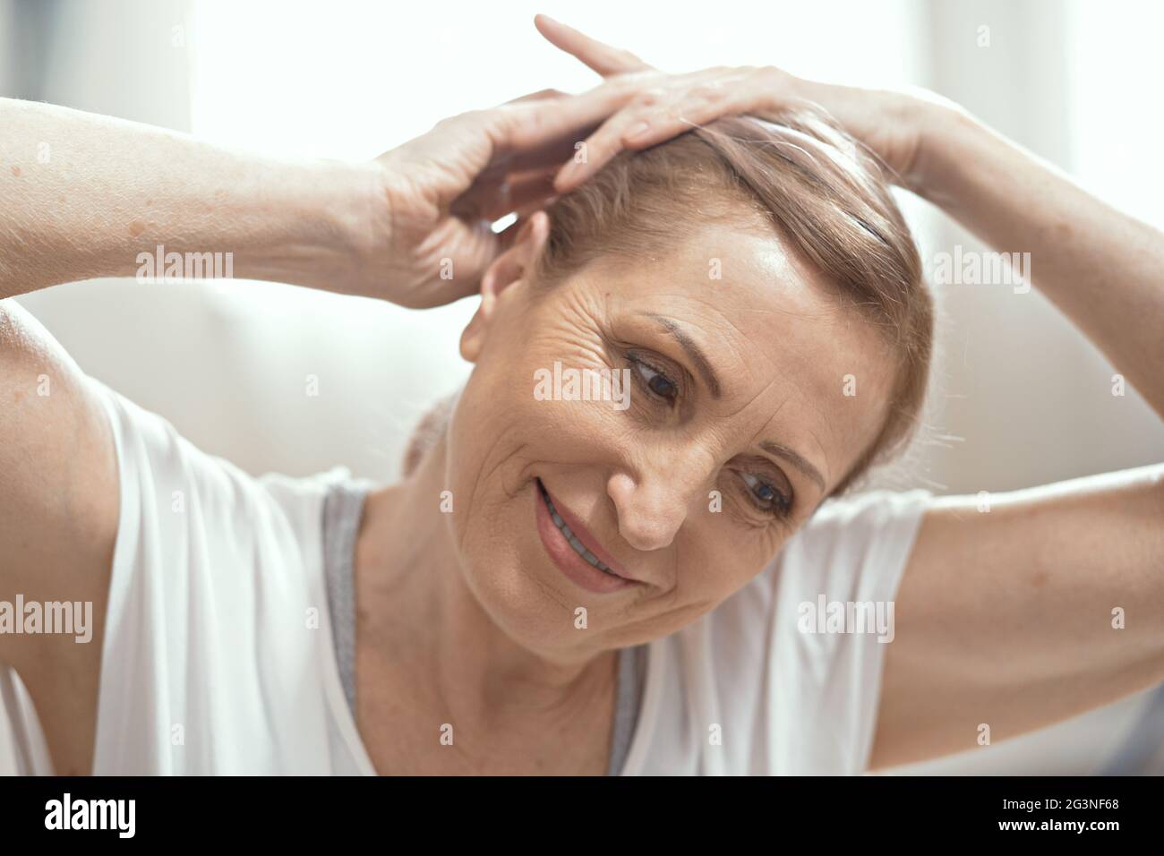 Erwachsene Frau im Alter von über 50 Jahren Yoga zu Hause. Stockfoto