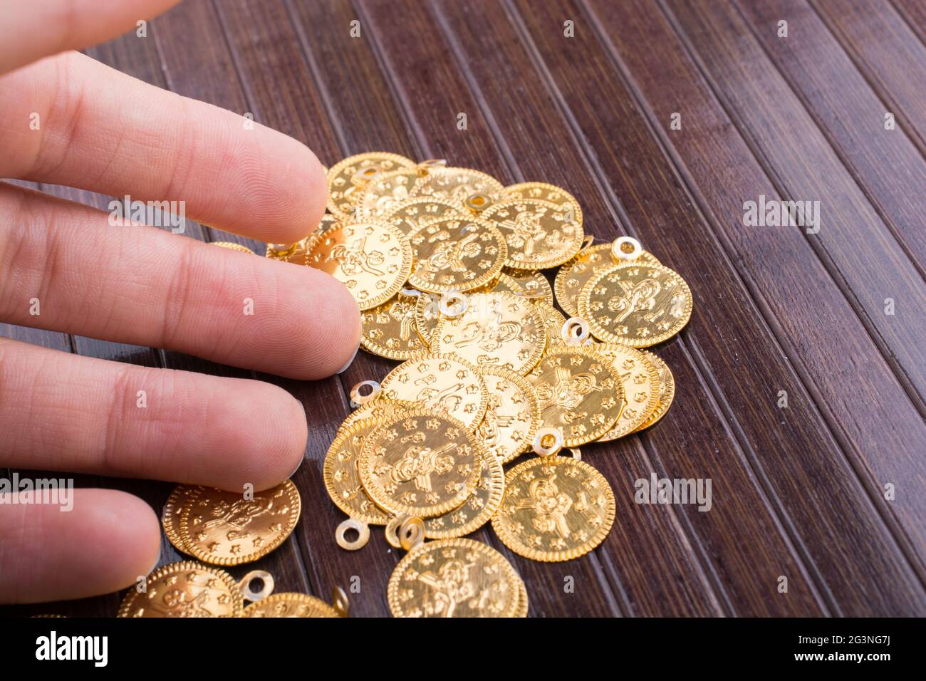 Viele gefälschte Goldmünzen in der Hand Stockfoto