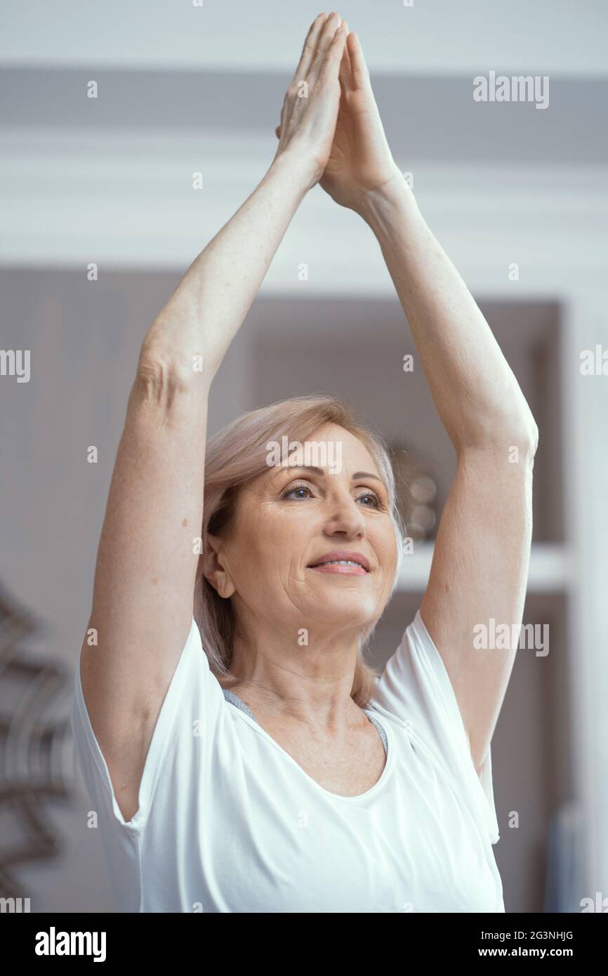 Die schöne Frau hält die Hände über dem Kopf zusammengedrückt Stockfoto