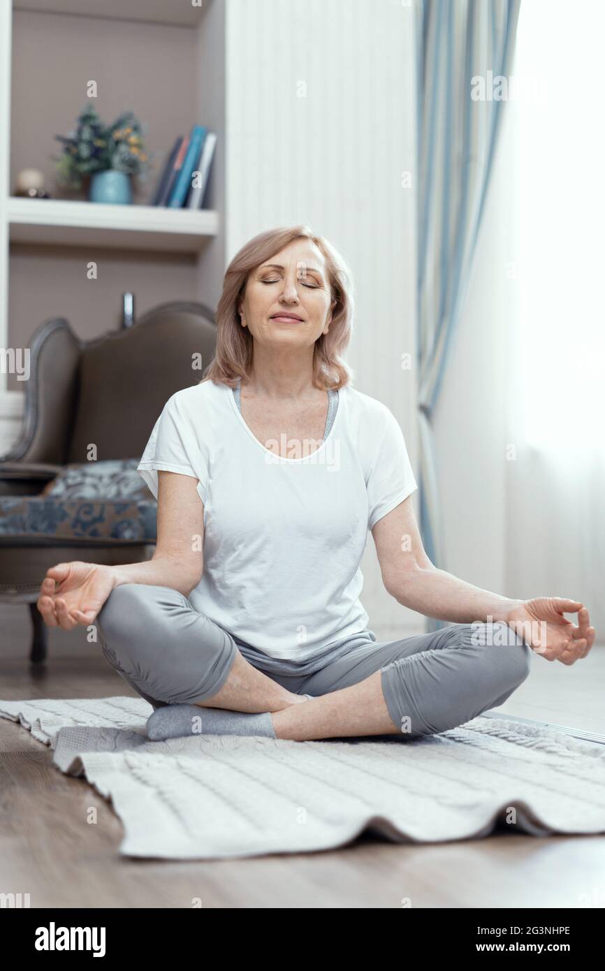 Frau sitzt mit gekreuzten Beinen. Yoga-Pose. Stockfoto