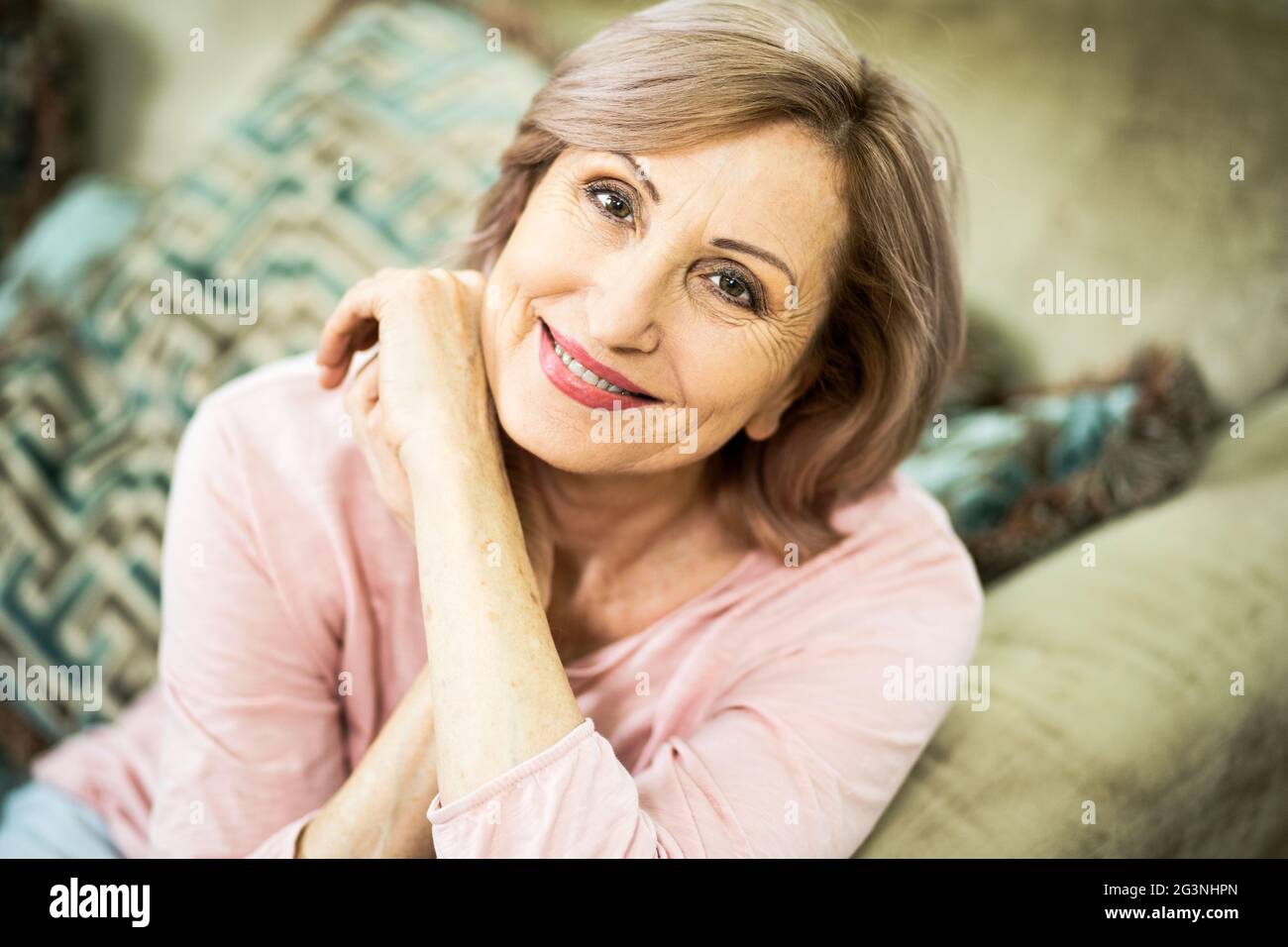 Porträt einer Frau über 50, die zu Hause im Wohnzimmer ist. Stockfoto