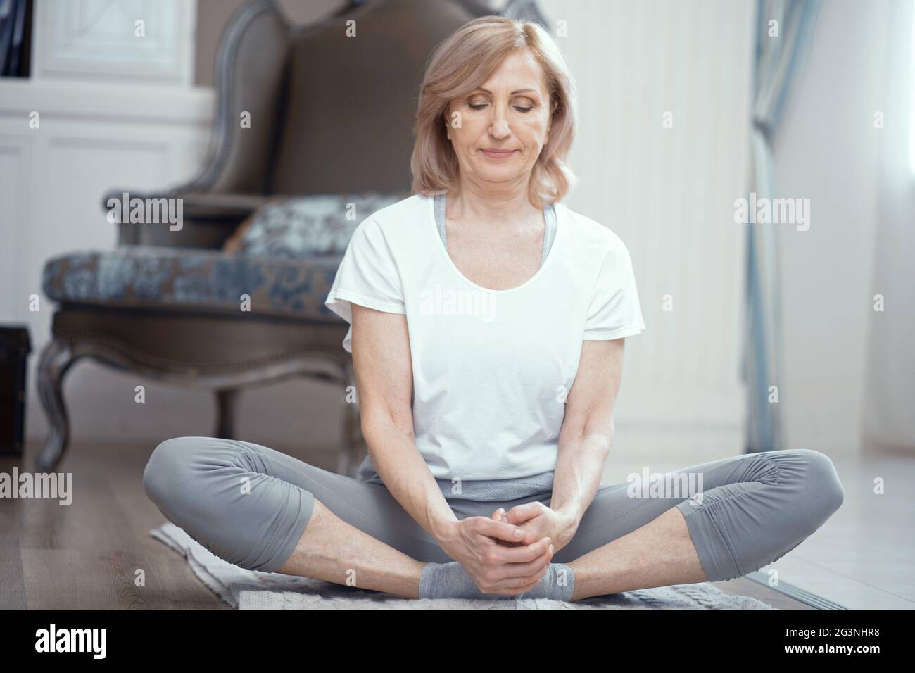 Frau sitzt mit gekreuzten Beinen. Yoga-Pose. Stockfoto