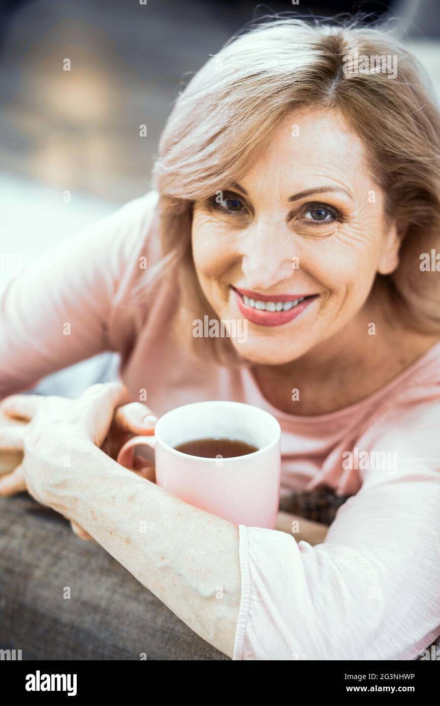 Eine Frau über 50 Jahre europäische Erscheinungsbild ruhen zu Hause Tee trinken. Stockfoto