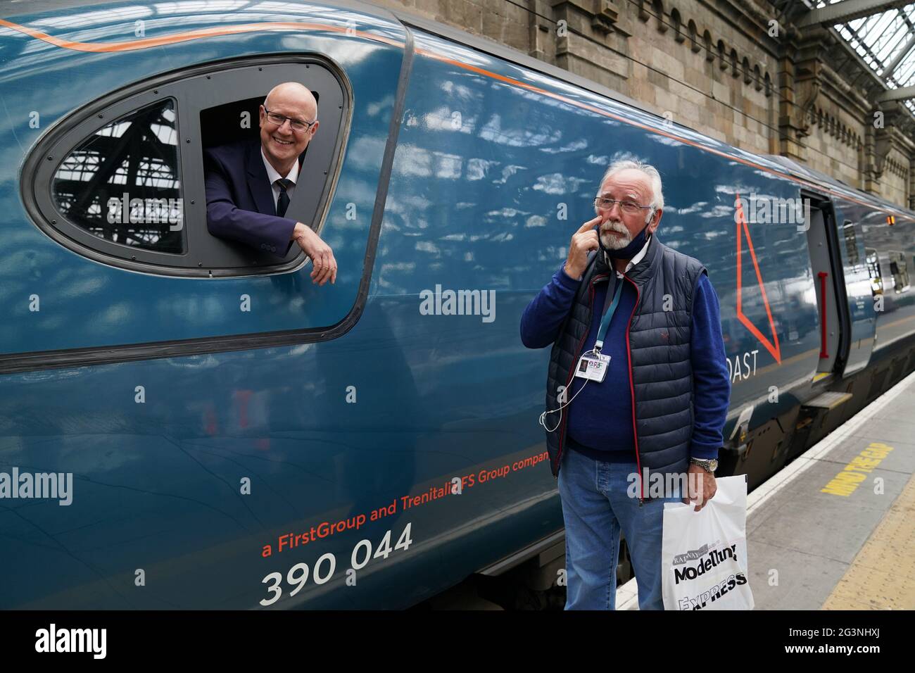 Zugfan Pete Waterman gibt vor, zu weinen, während er mit dem Lokführer Neil Barker an Bord des Avanti-Westküsten-Emu-Zuges der Klasse 390 spricht, der von London Euston aus am Hauptbahnhof Glasgow angekommen ist, nachdem er den 36 Jahre alten Rekord für die schnellste Zugfahrt zwischen London und Glasgow nicht gebrochen hat. Der Royal Scot-Zug erreichte Glasgow Central 21 Sekunden hinter dem Rekord von drei Stunden, 52 Minuten und 40 Sekunden, den British Rail im Dezember 1984 aufgestellt hatte.Bilddatum: Donnerstag, 17. Juni 2021. Stockfoto