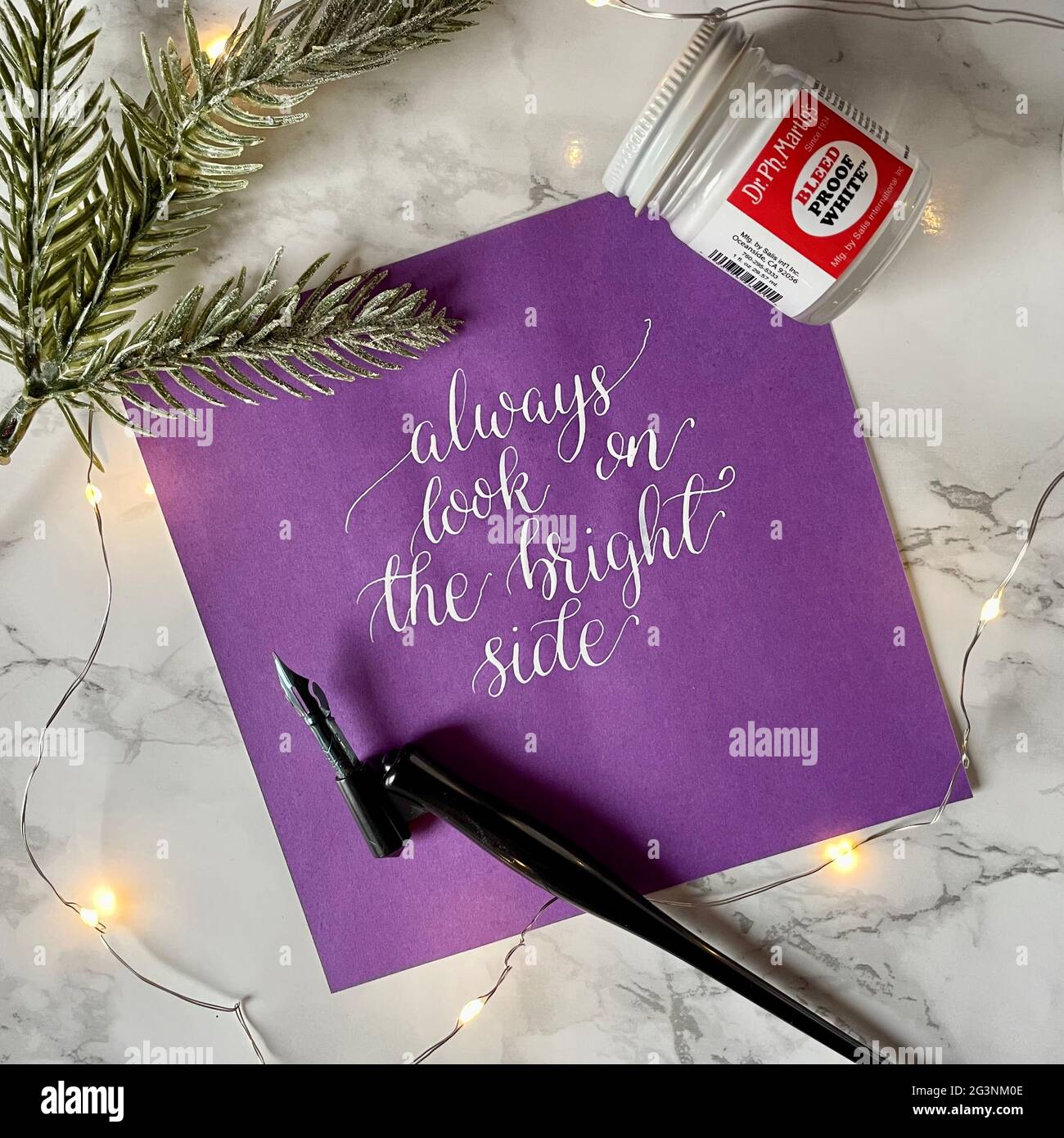 Schauen Sie immer auf die helle Seite - weiße Tinte Moderne Kalligraphie mit spitzen Stift Stockfoto