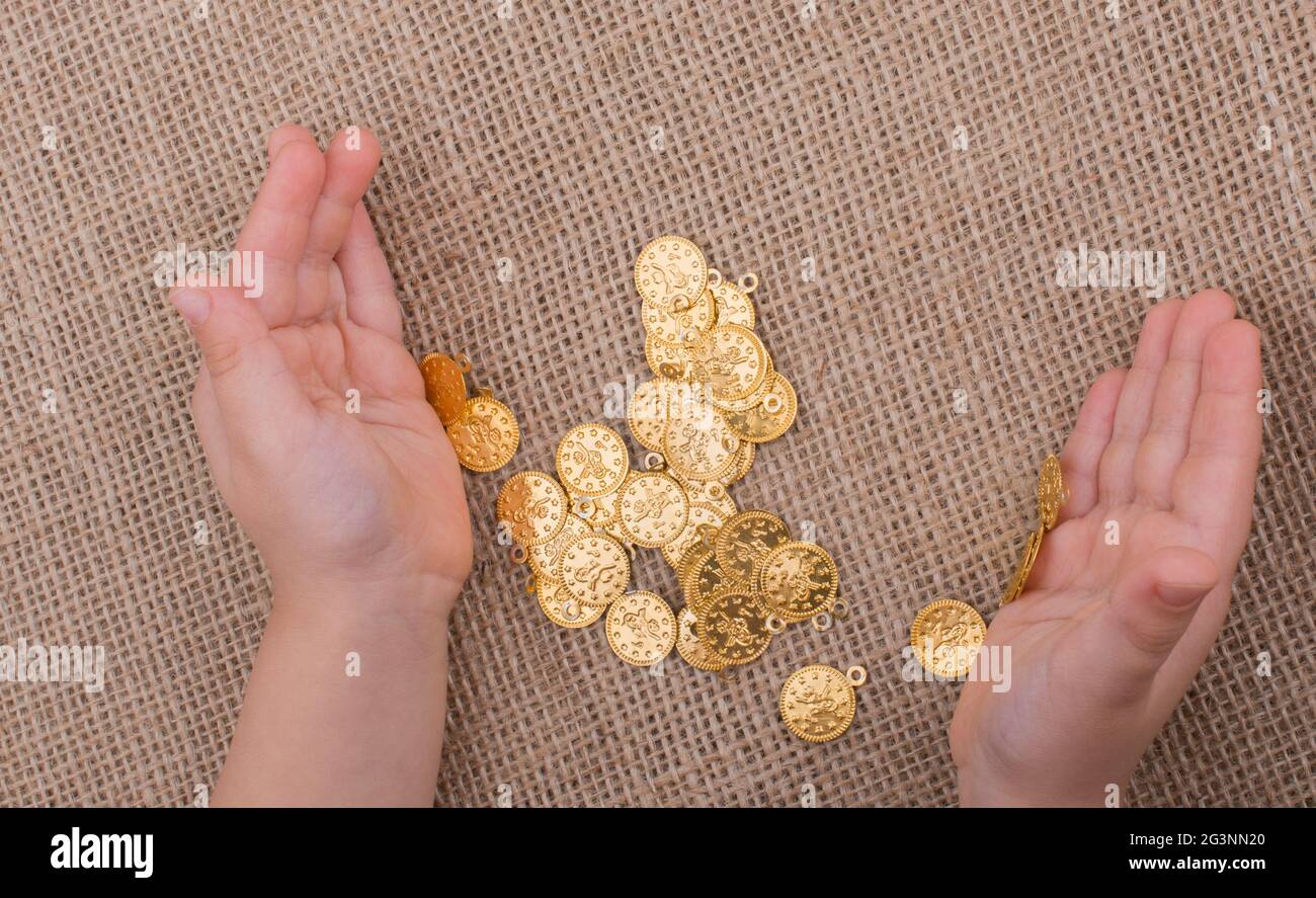 Viele gefälschte Goldmünzen in der Hand Stockfoto