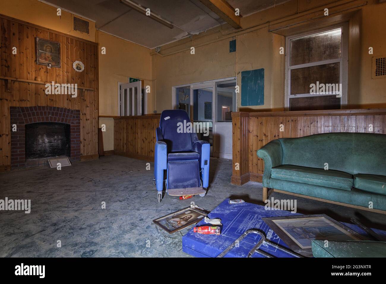 Der Tagesraum der Einrichtung hatte Sofas und Sessel vor einem offenen Kamin. MIDLANDS, IRLAND: BETRETEN SIE eines der BEUNRUHIGENDSTEN verlassenen AS Irlands Stockfoto