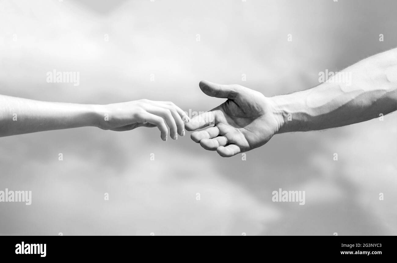Hände von Mann und Frau, die sich gegenseitig erreichen, unterstützen. Eine helfende Hand geben. Schwarz und Weiß Stockfoto