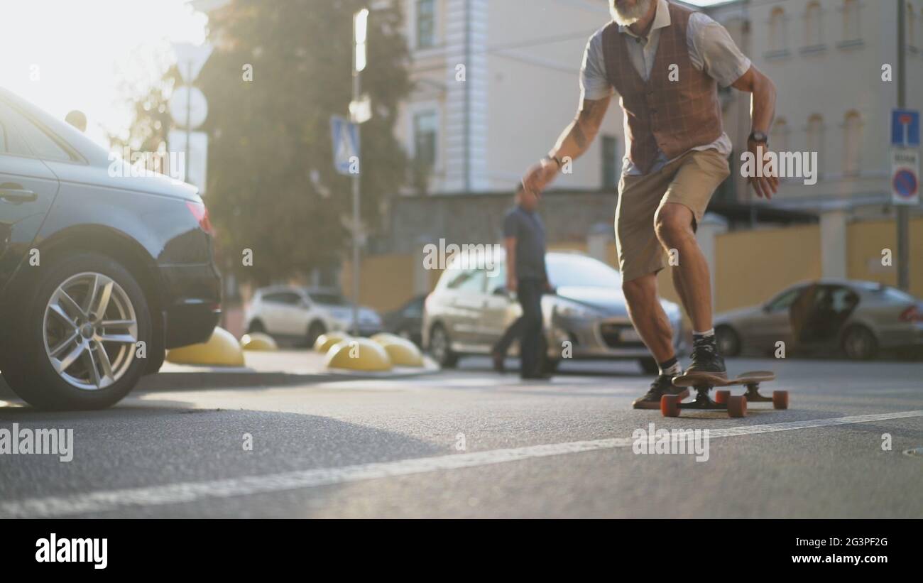 Intelligenter Mann, Der mit Skateboard Spaß am Extremsport hat Stockfoto